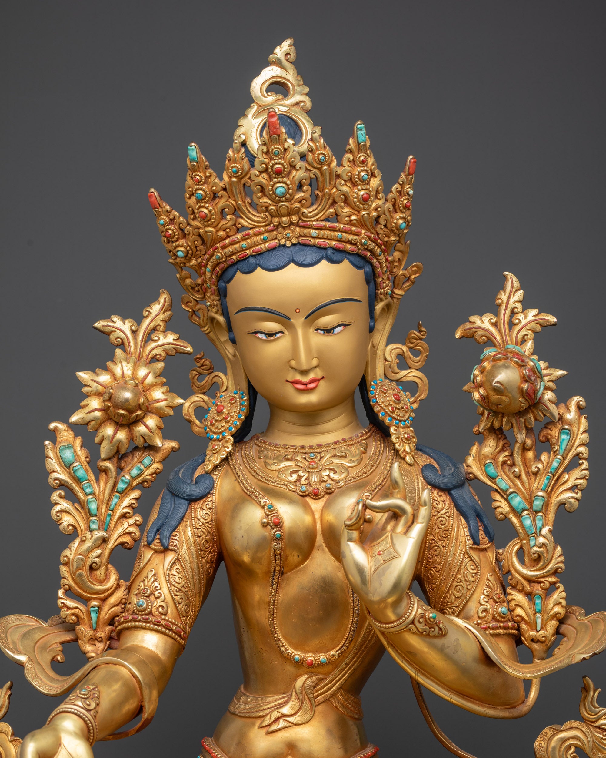 Close up of Green Tara Statue highlighting crown, robes, and utpala flower