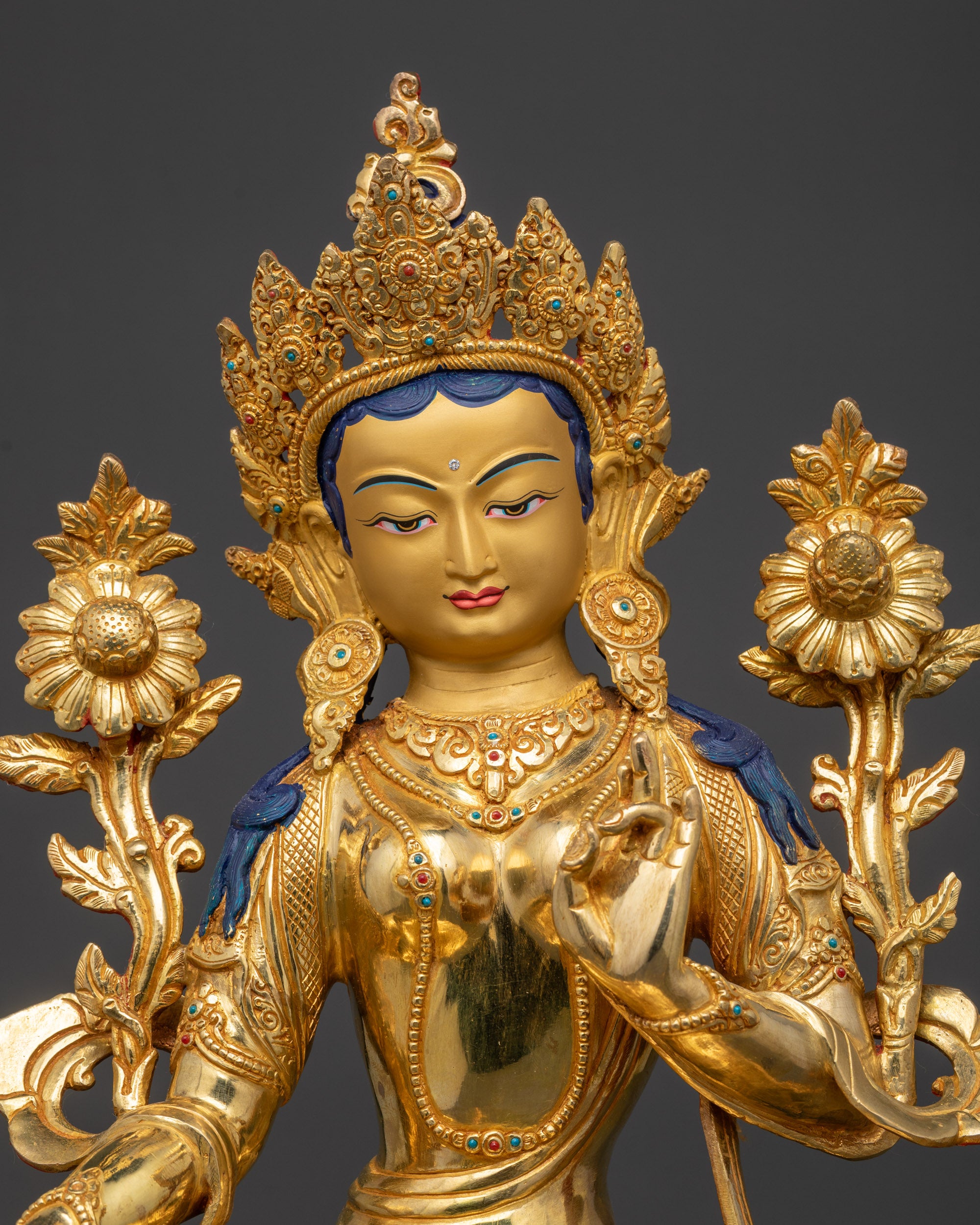 Close up of Green Tara holding Utpala flower and adorned robe with semi-precious stones