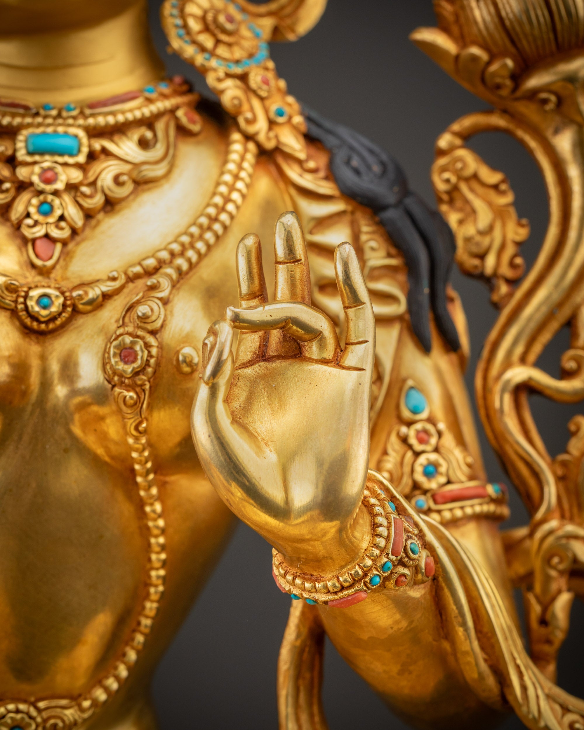 Close up of Green Tara right hand in varada mudra on lotus seat