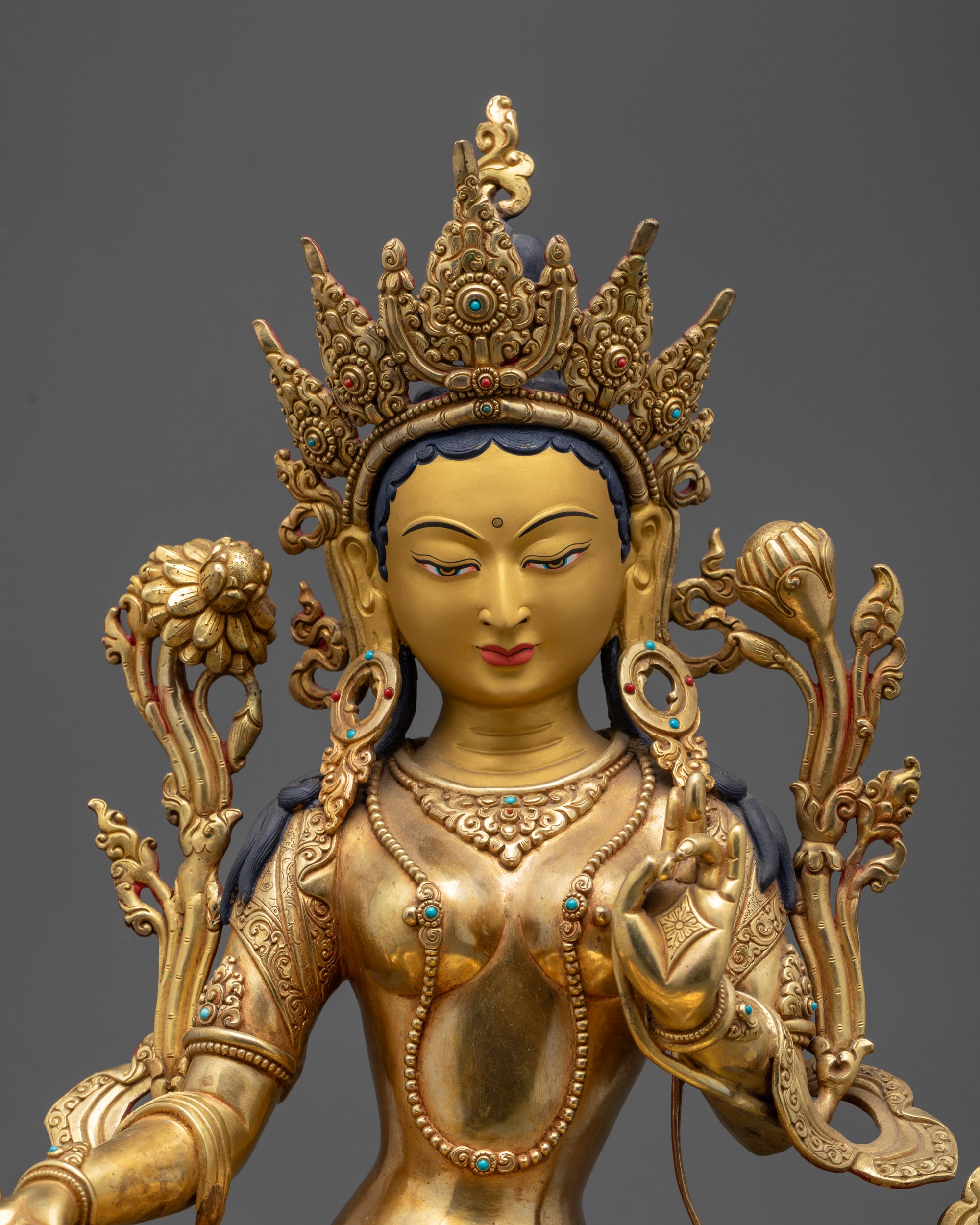 Close up of Green Tara’s gold-gilded face, Five-Jeweled Crown, and semi-precious stones