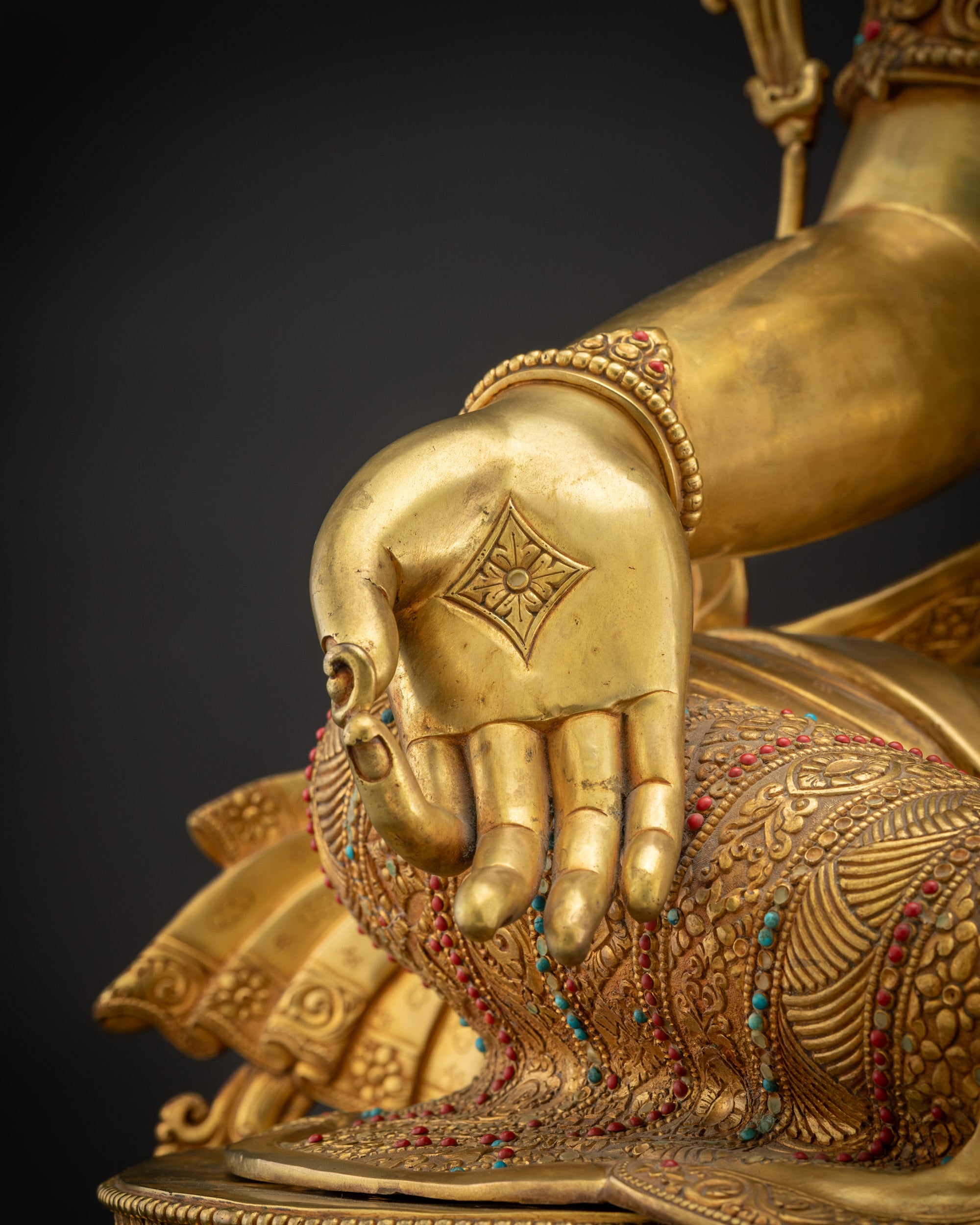 Close up of Green Tara statue Varada mudra right hand with intricate detail
