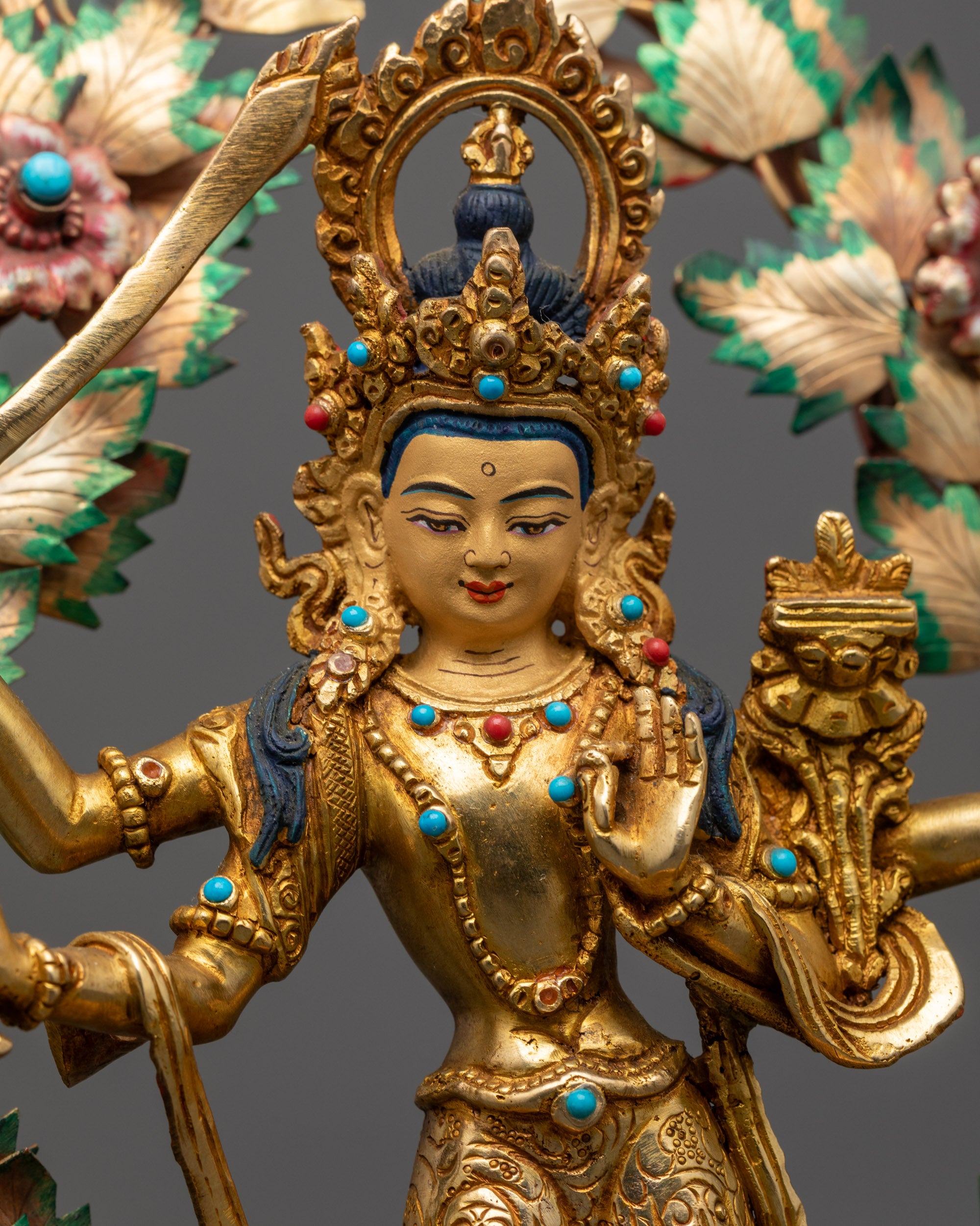 Close up of Maha Manjushri statue showing flaming sword, bow, arrow, and intricate details