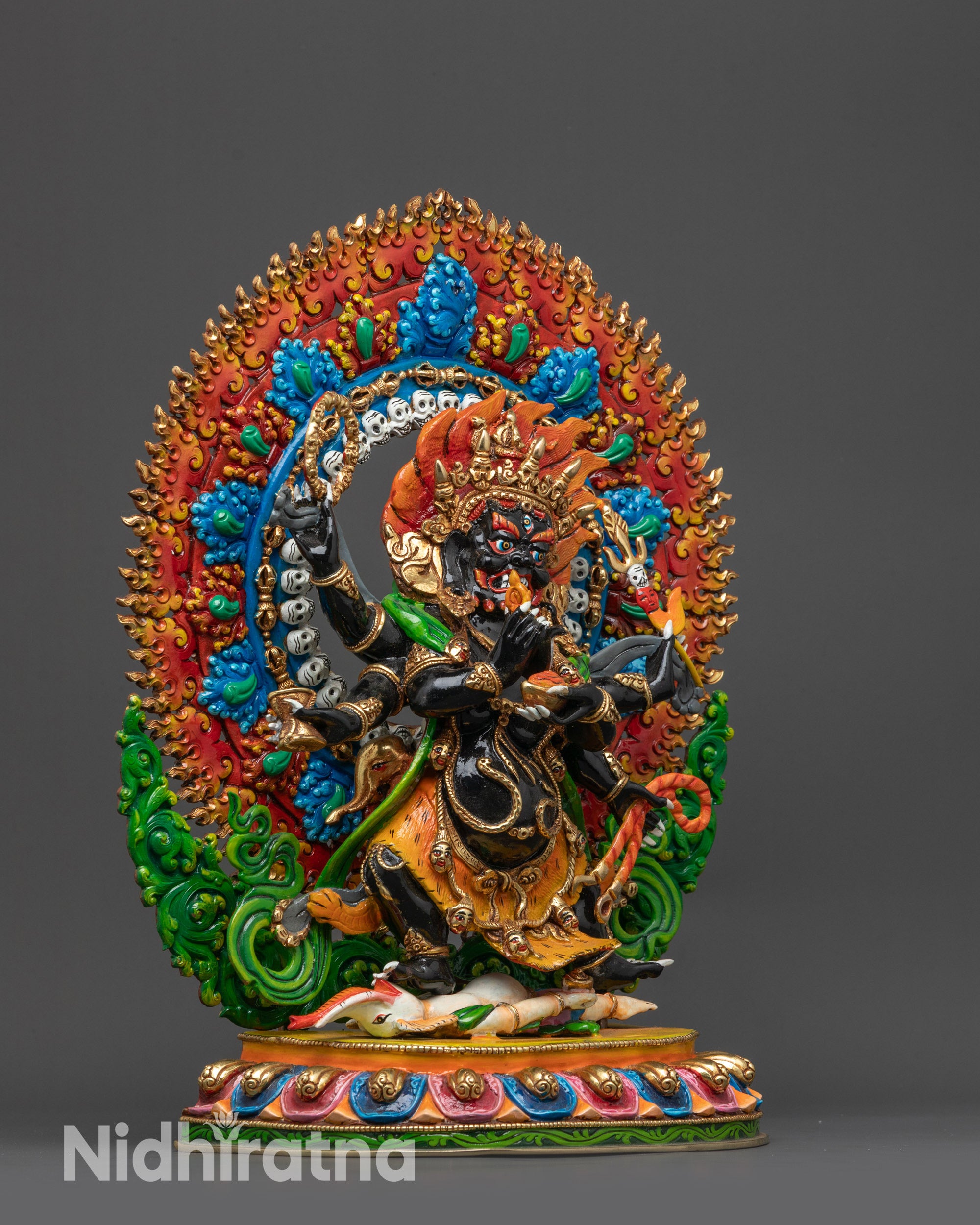 Close up of Mahakala's third eye, bared fangs, red eyebrows and detailed skull garland