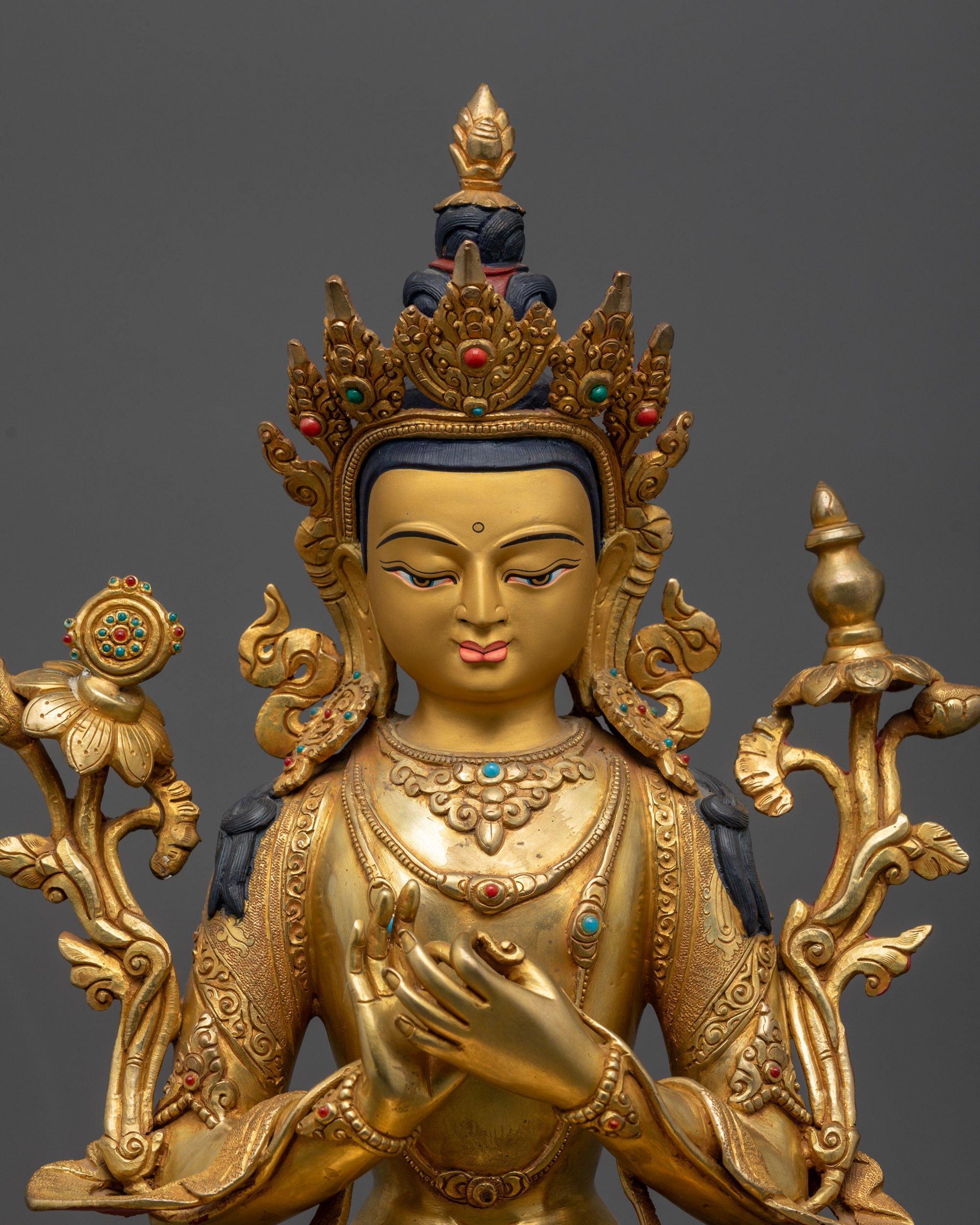 Close up of Maitreya Buddha sculpture showing intricate robe patterns and Dharmachakra Mudra