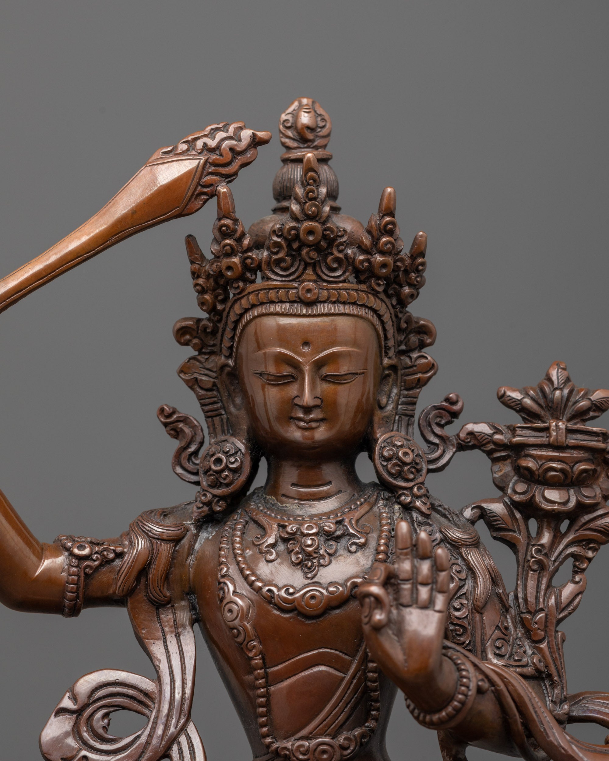 Close up of Manjushri’s flaming sword and ornate halo with sacred symbols and deities