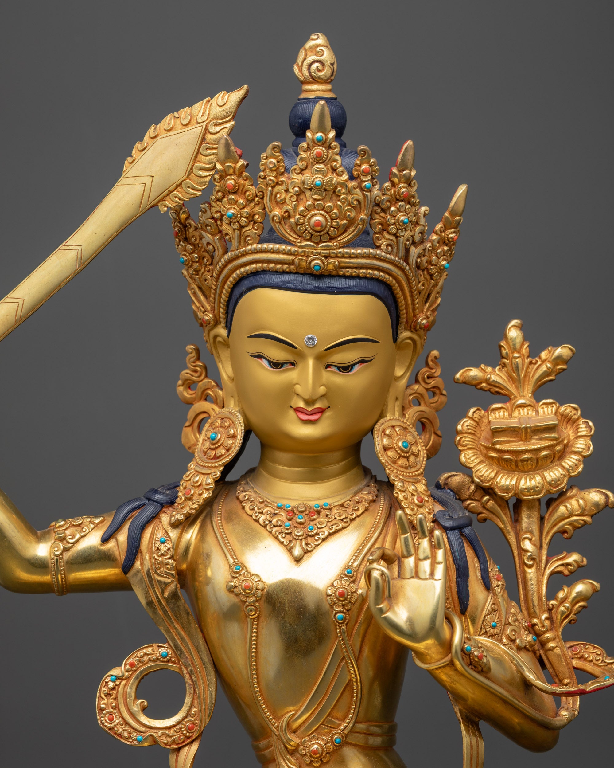 Close up of Monju Bosatsu Statue showing semi-precious stones on robe, crown, and jewelry