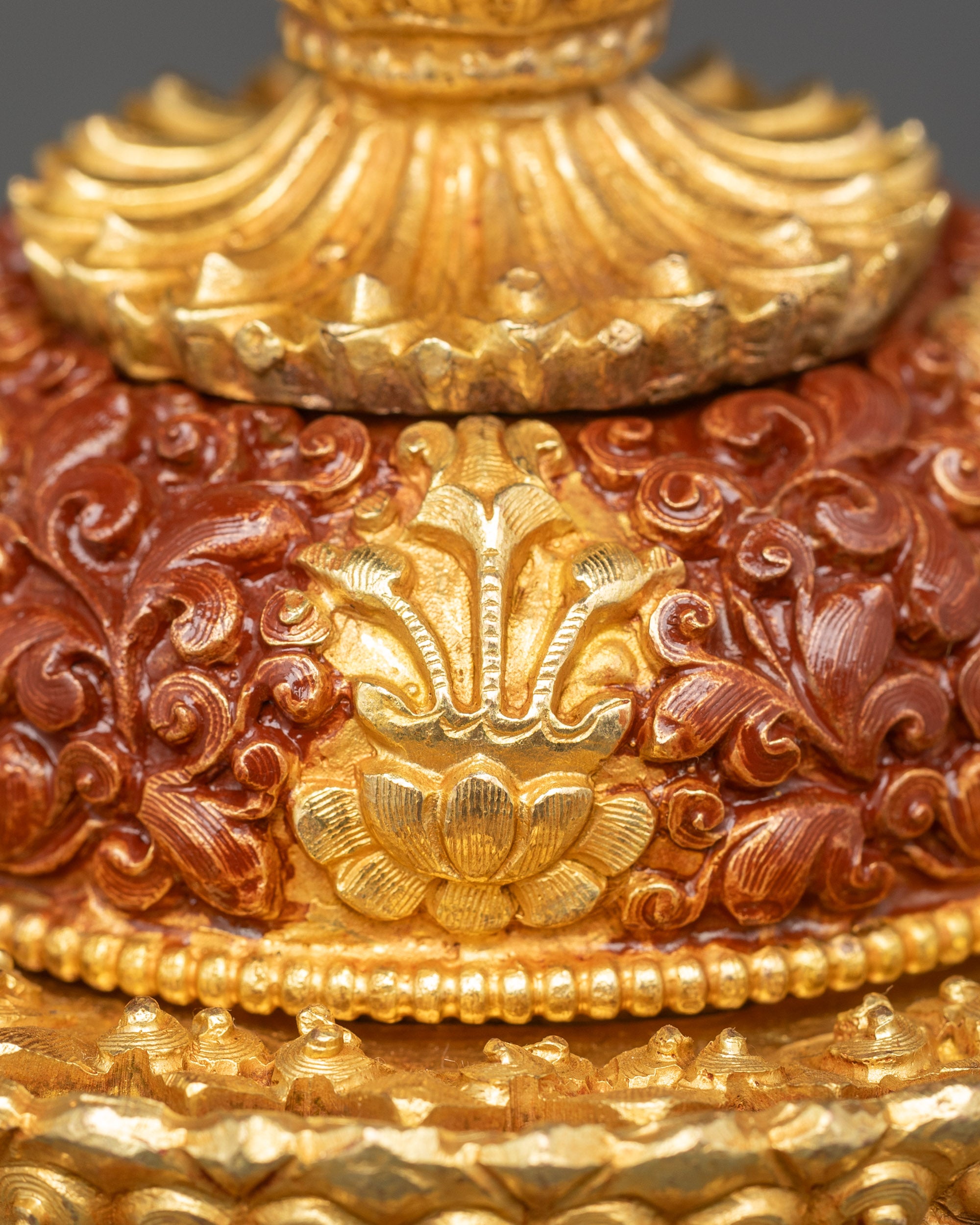 Close up of Neshi rice pot finial shaped like lotus bud, gold-plated with intricate paint