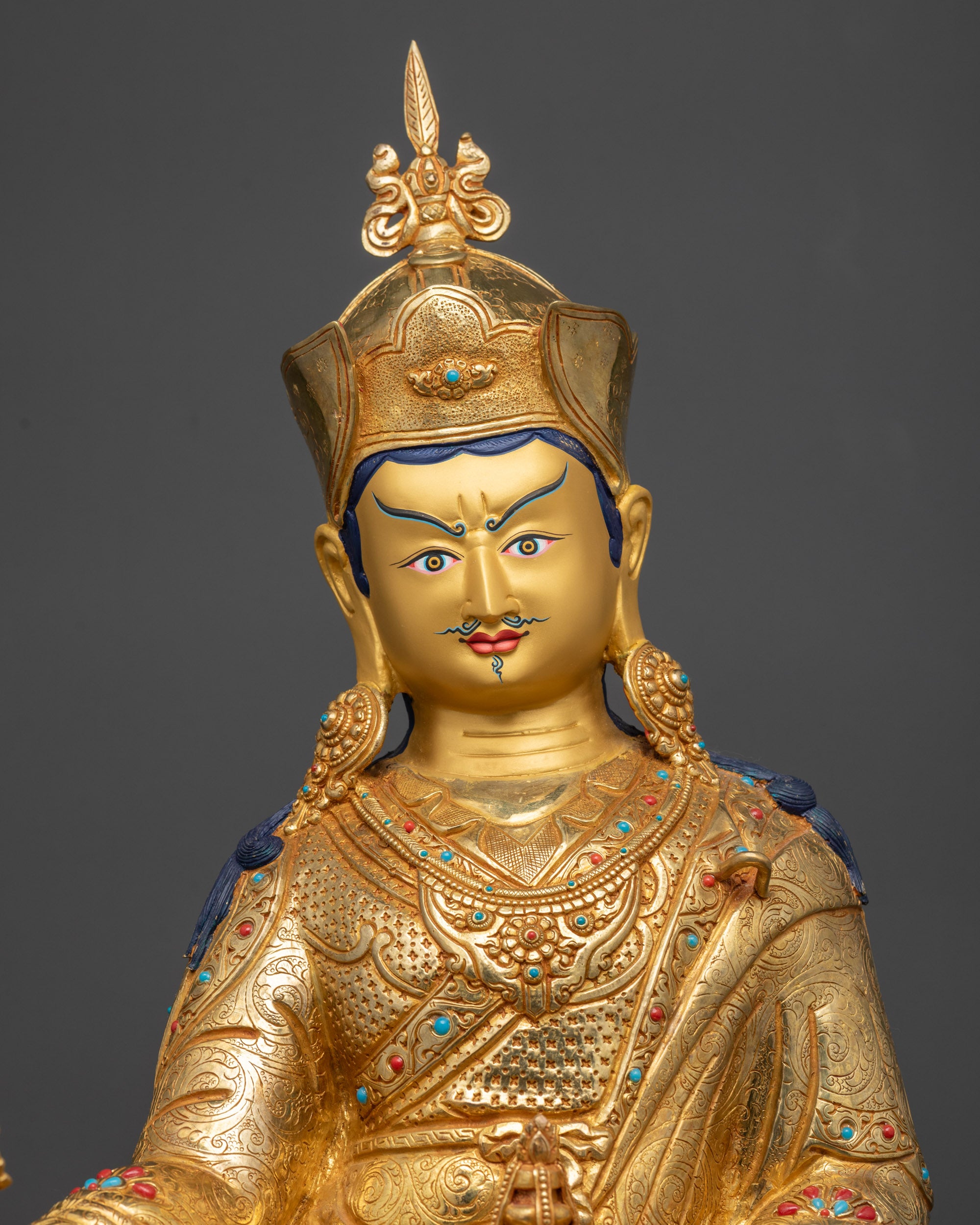 Close up of Padmasambhava statue showing skull cup, vajra, and khatvanga staff