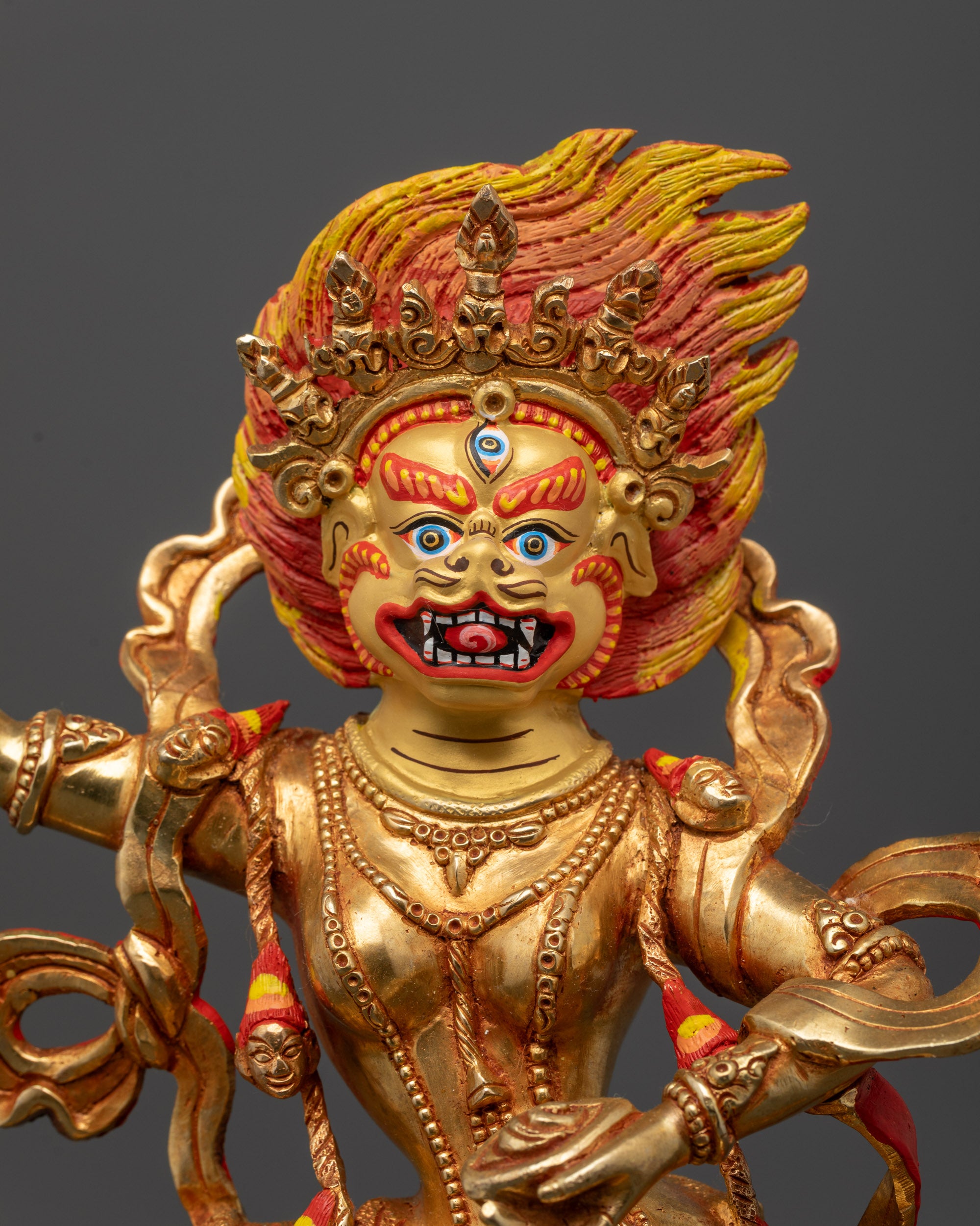 Close up of Simhamukha third eye face with five-skull crown and trident details