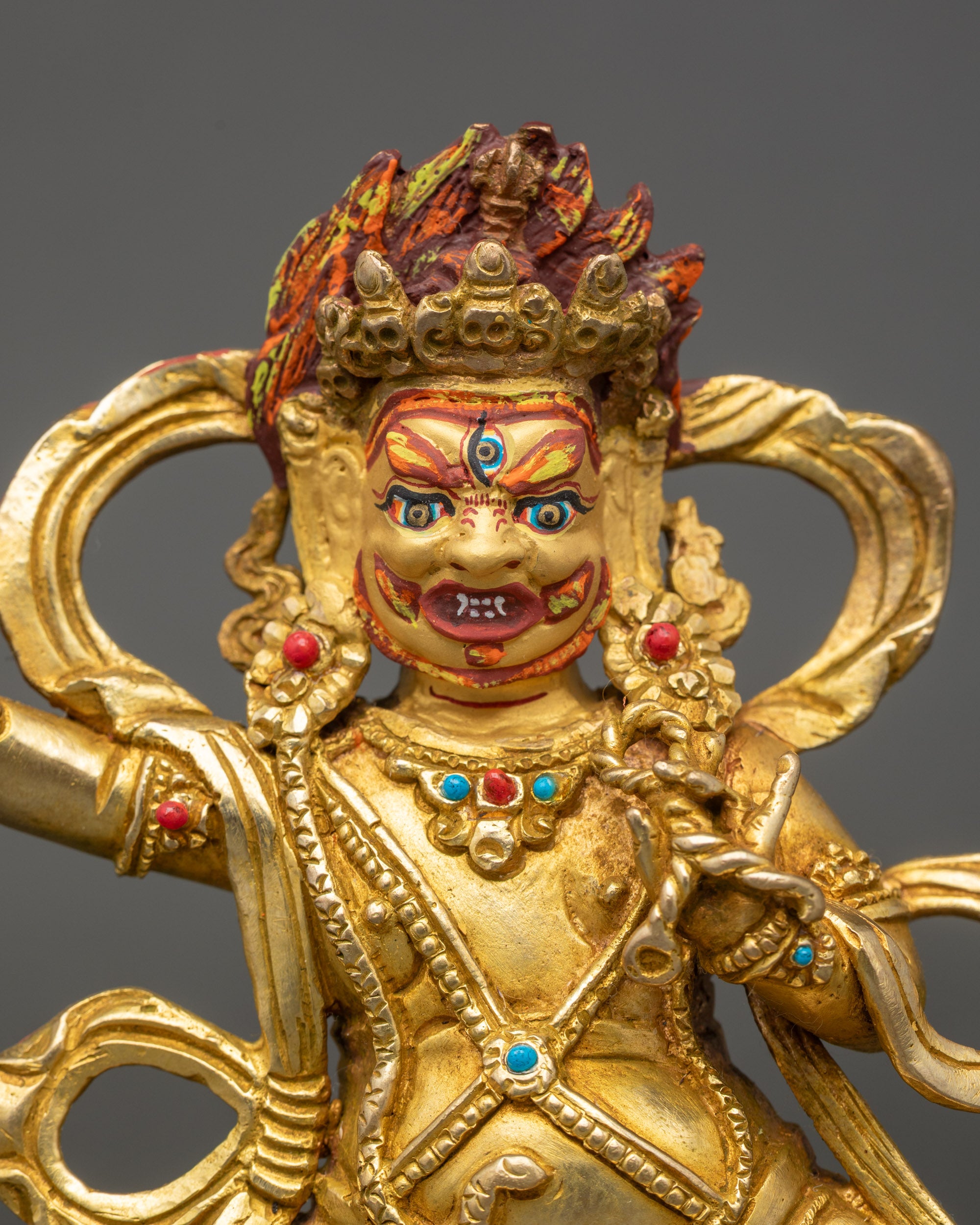 Close up of Vajrapani gold painted face with fierce compassionate expression