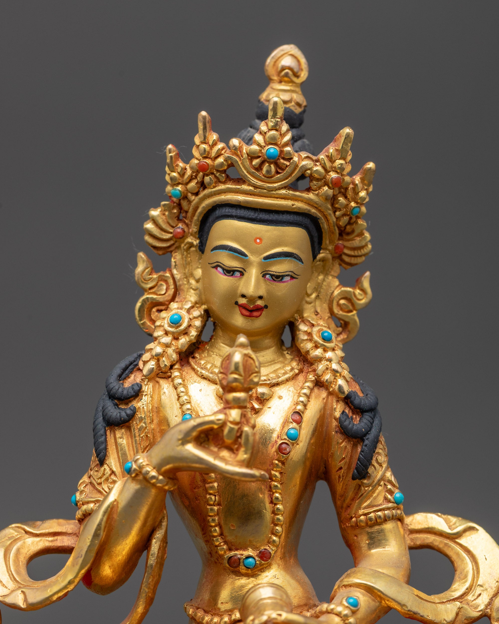 Close up of Vajrasattva crown, earrings, jewelry, and armlets on copper alloy statue