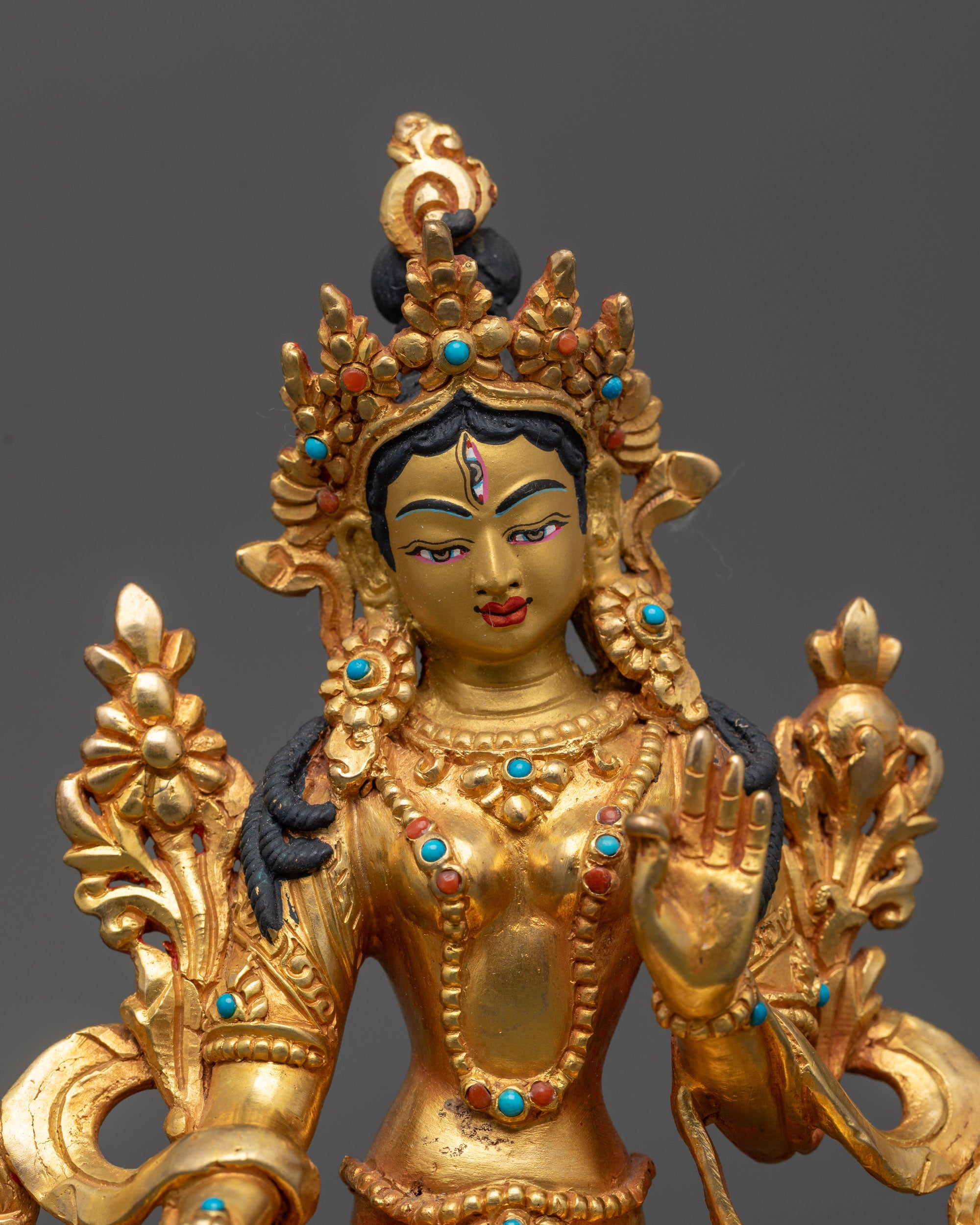 Close up of White Tara sculpture showing serene expression and seven eyes for protection