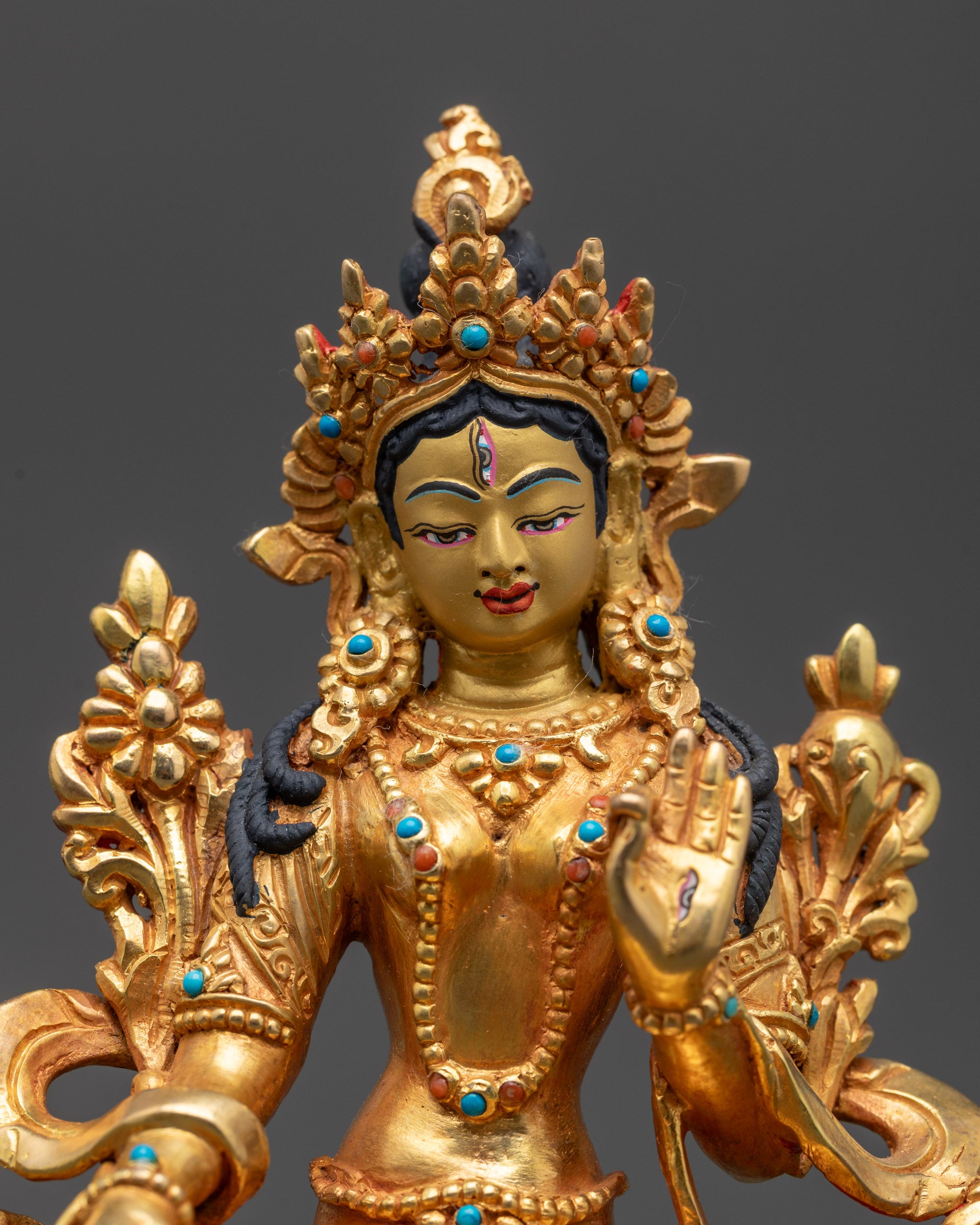 Close up of White Tara statue showing gold fire-gilding and semi-precious stones