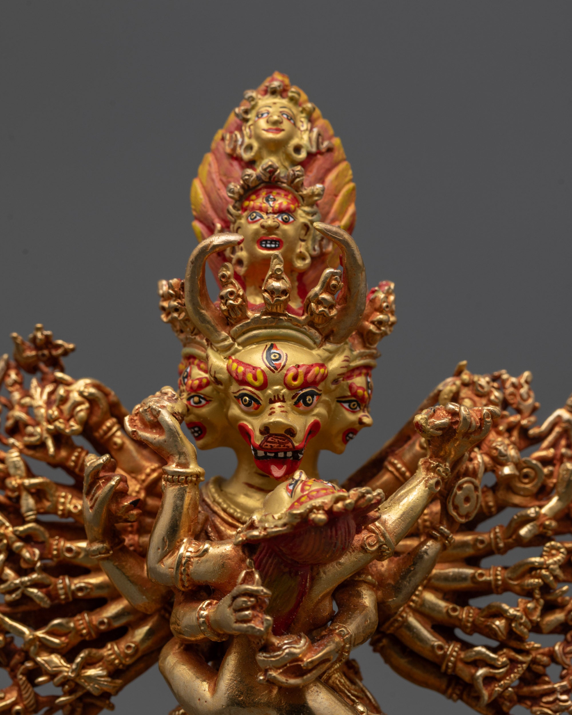 Close up of Yamantaka Yab-Yum statue highlighting nine faces and sixteen arms on copper base