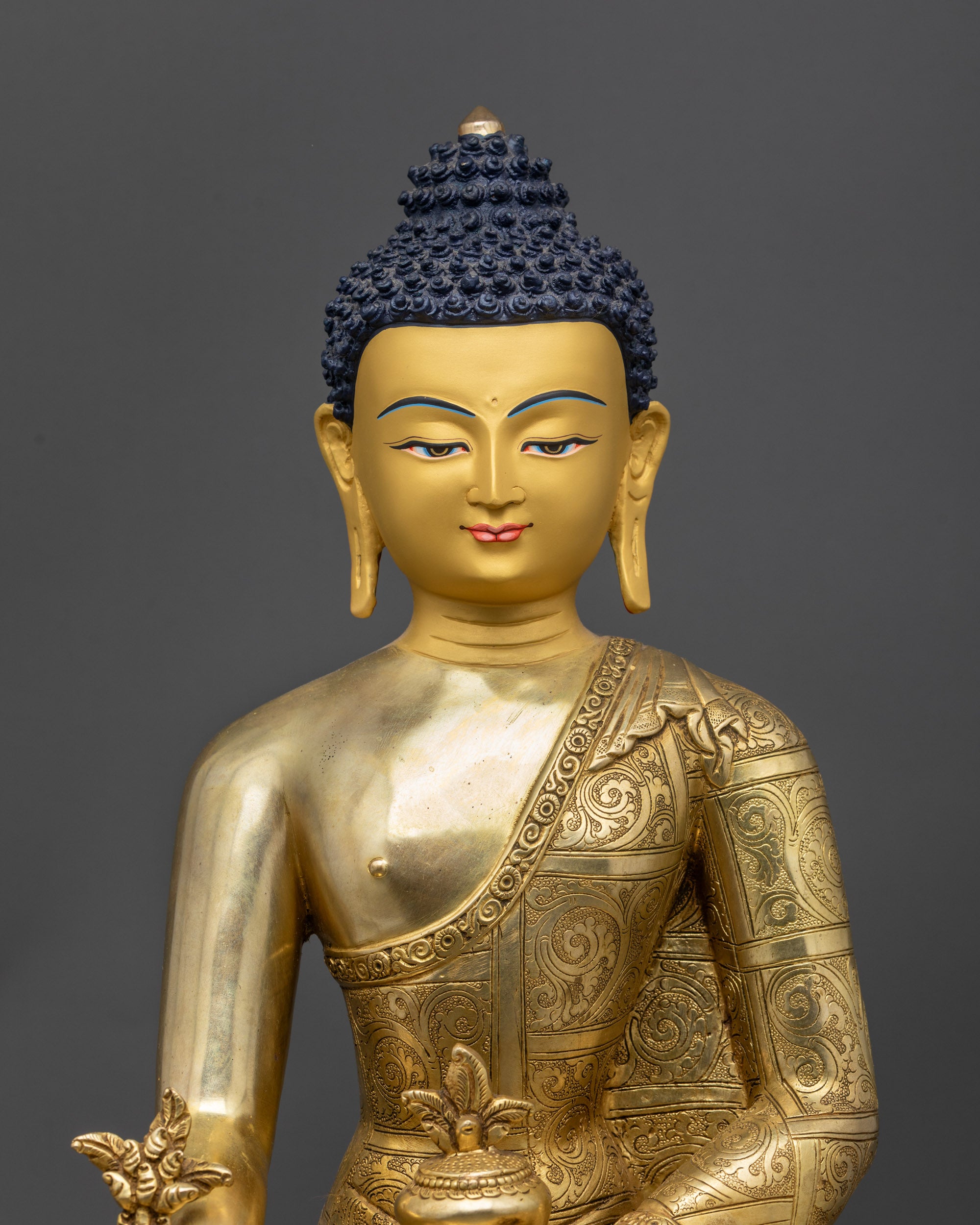 Close up of carved robes and garments with intricate Himalayan patterns