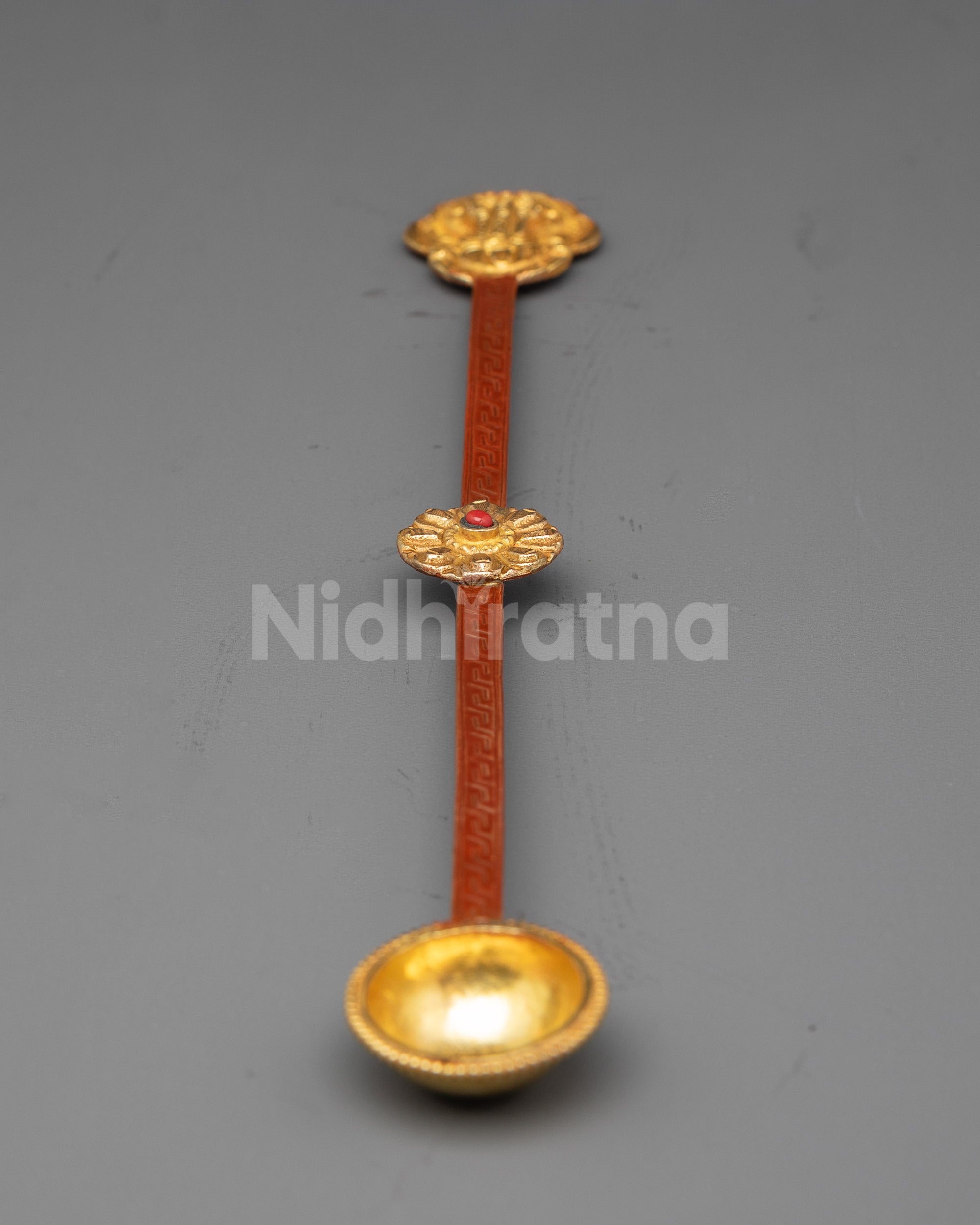 Close up of gold-plated scooping bowl on Tibetan ritual spoon