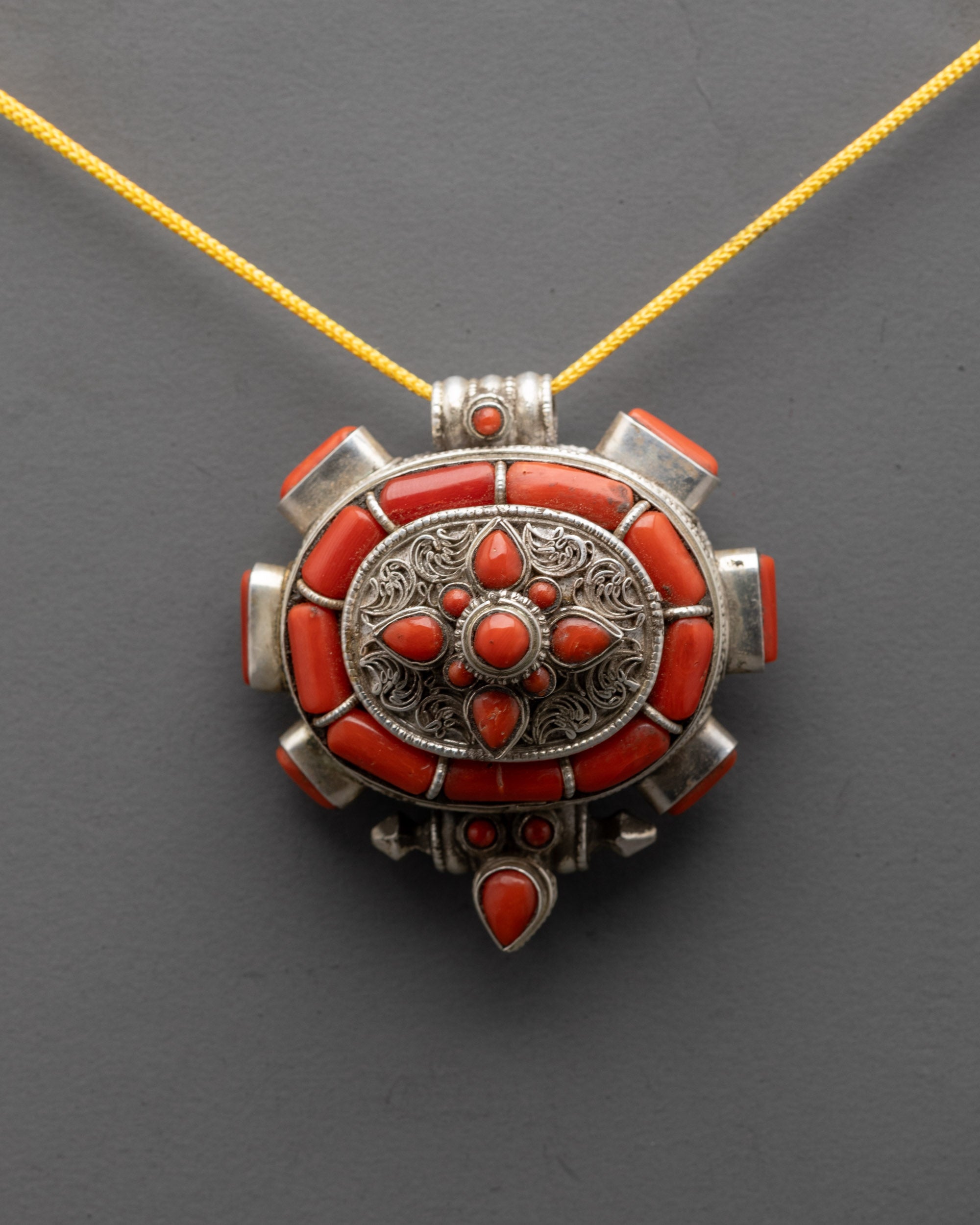 Close up of handcrafted silver filigree and coral stones on Red Coral Pendant