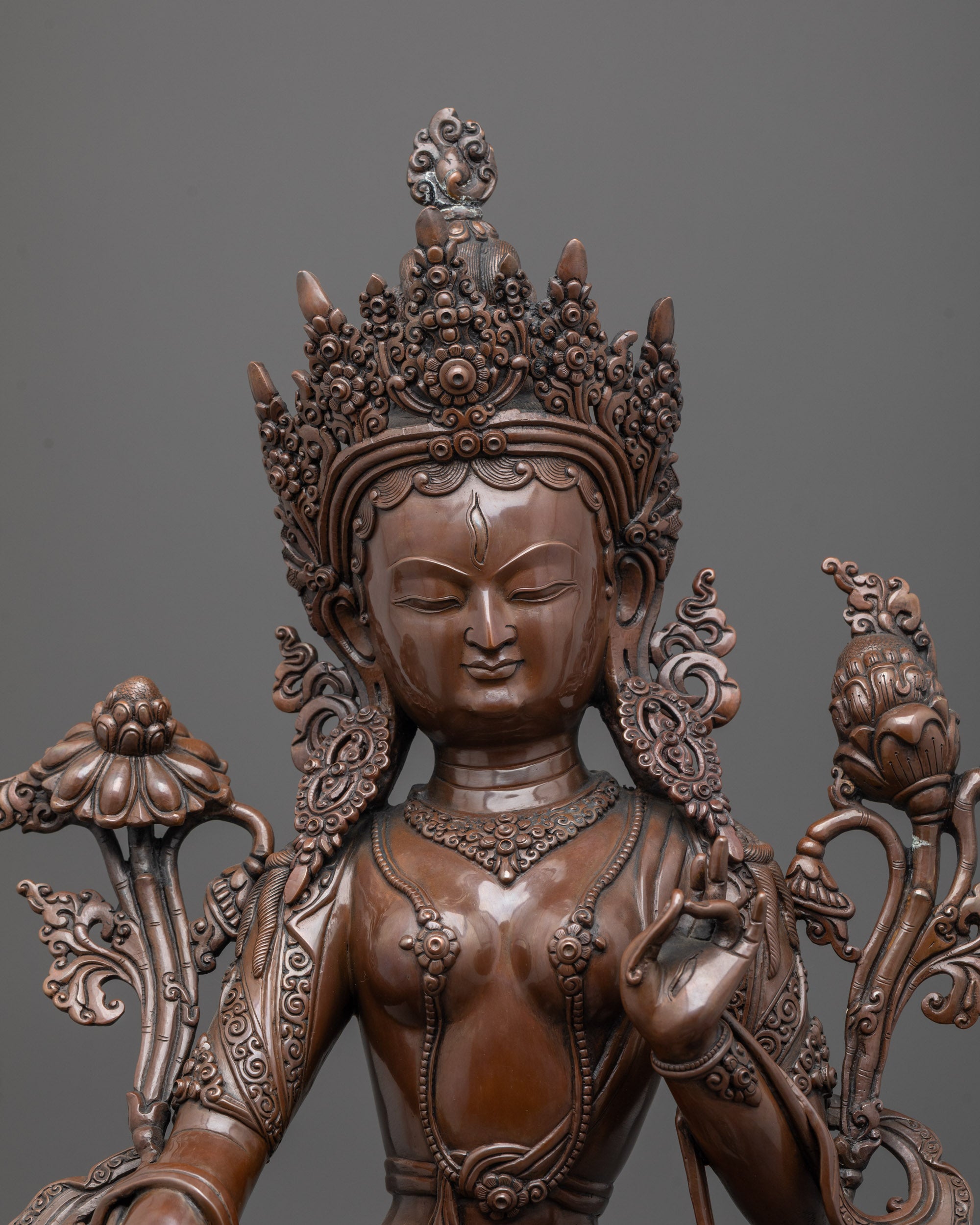 Close up of oxidized copper face and intricate carvings on White Tara meditation statue