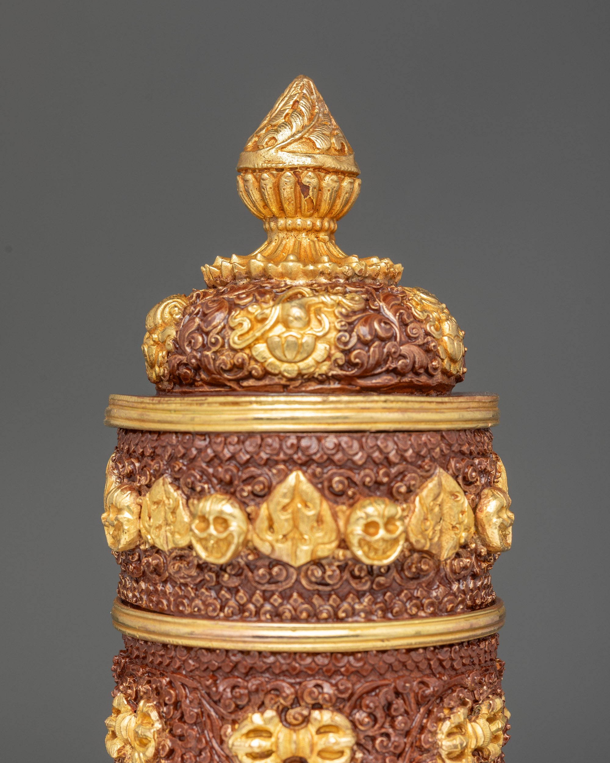 Close up of rice pot showing gold-plated vajra, skull, and auspicious motifs
