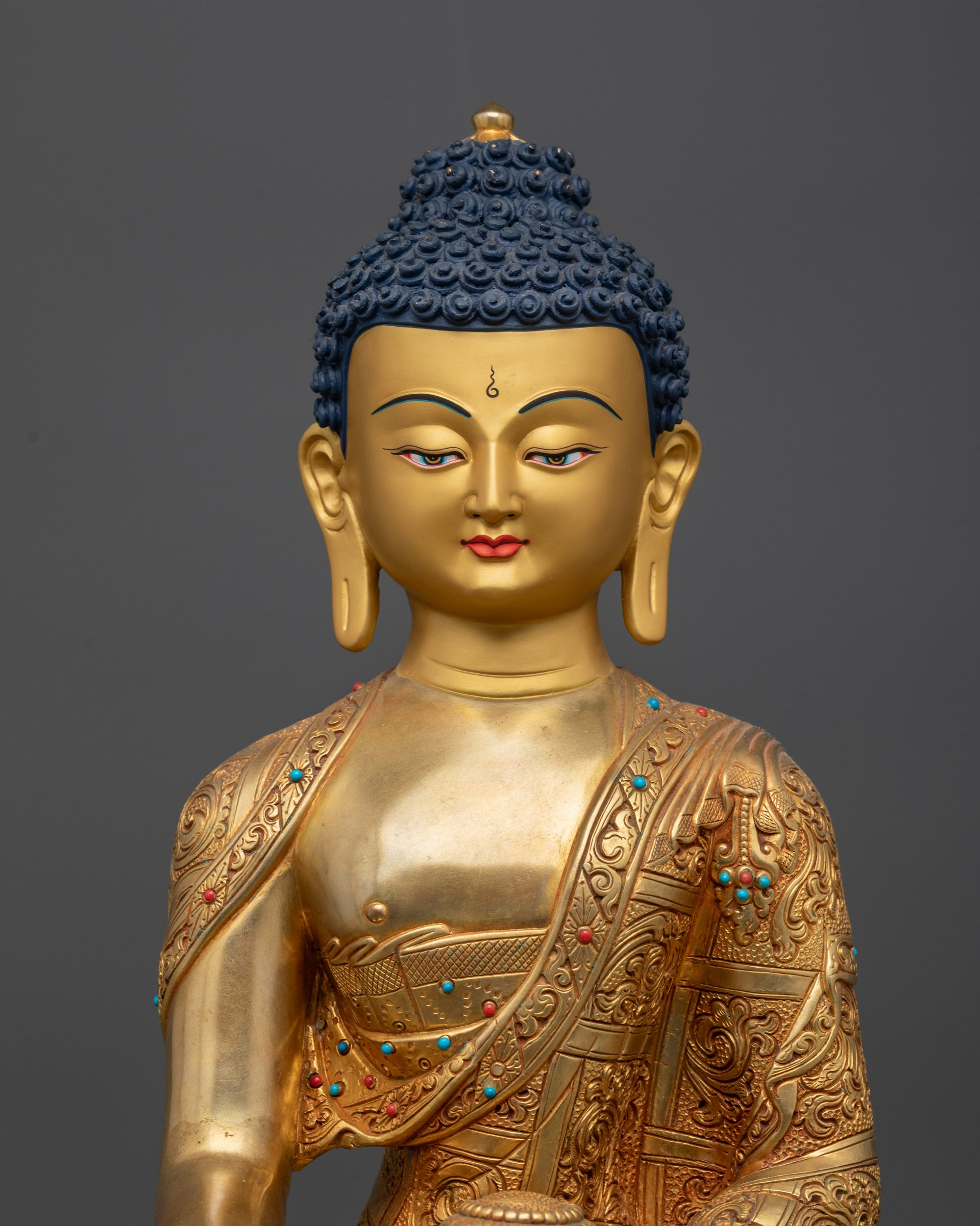 Close up of serene facial expression and intricately carved monk robe on Buddha statue