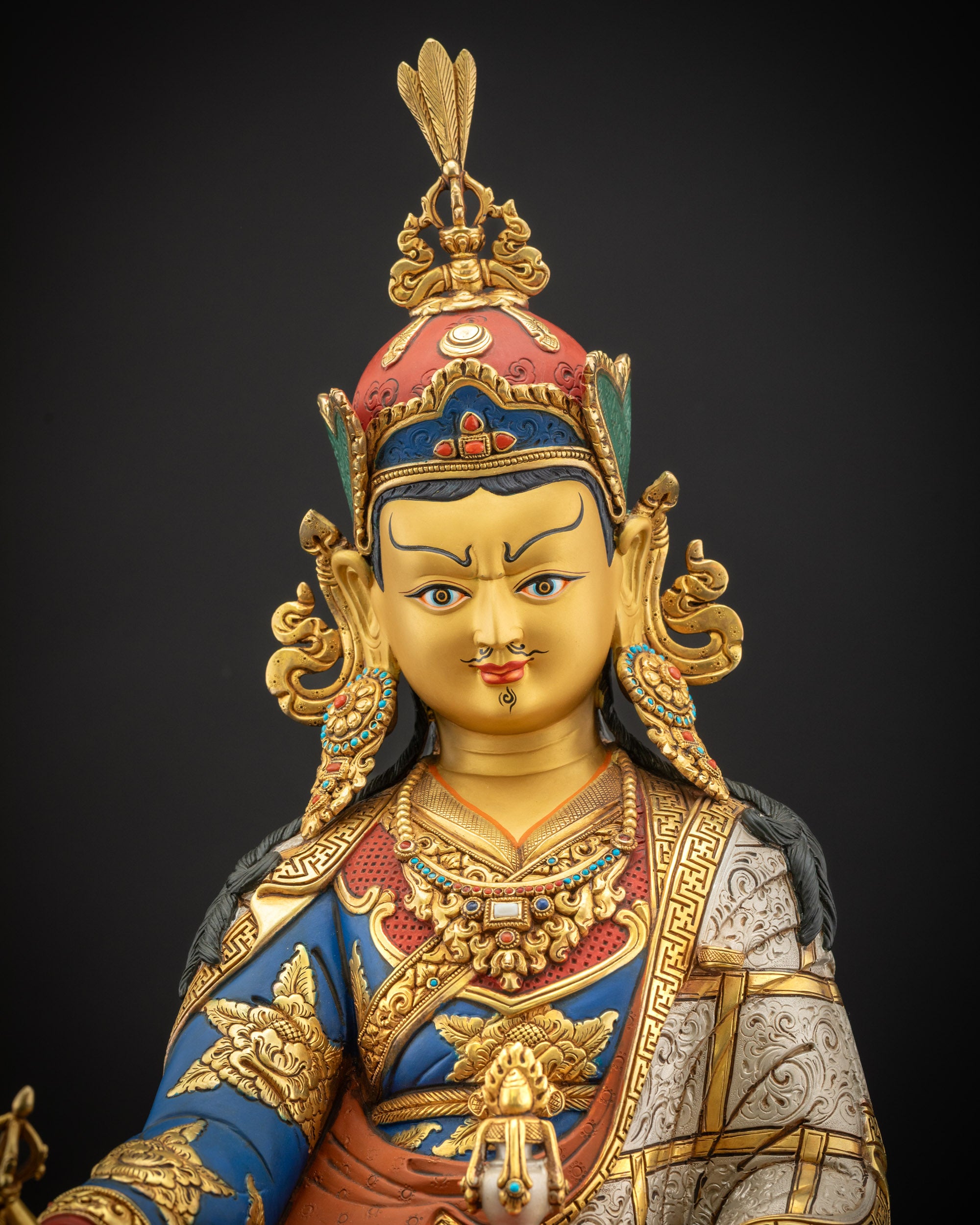 Close up view of Guru Padmasambhava statue highlighting 3D carving and gold gilding