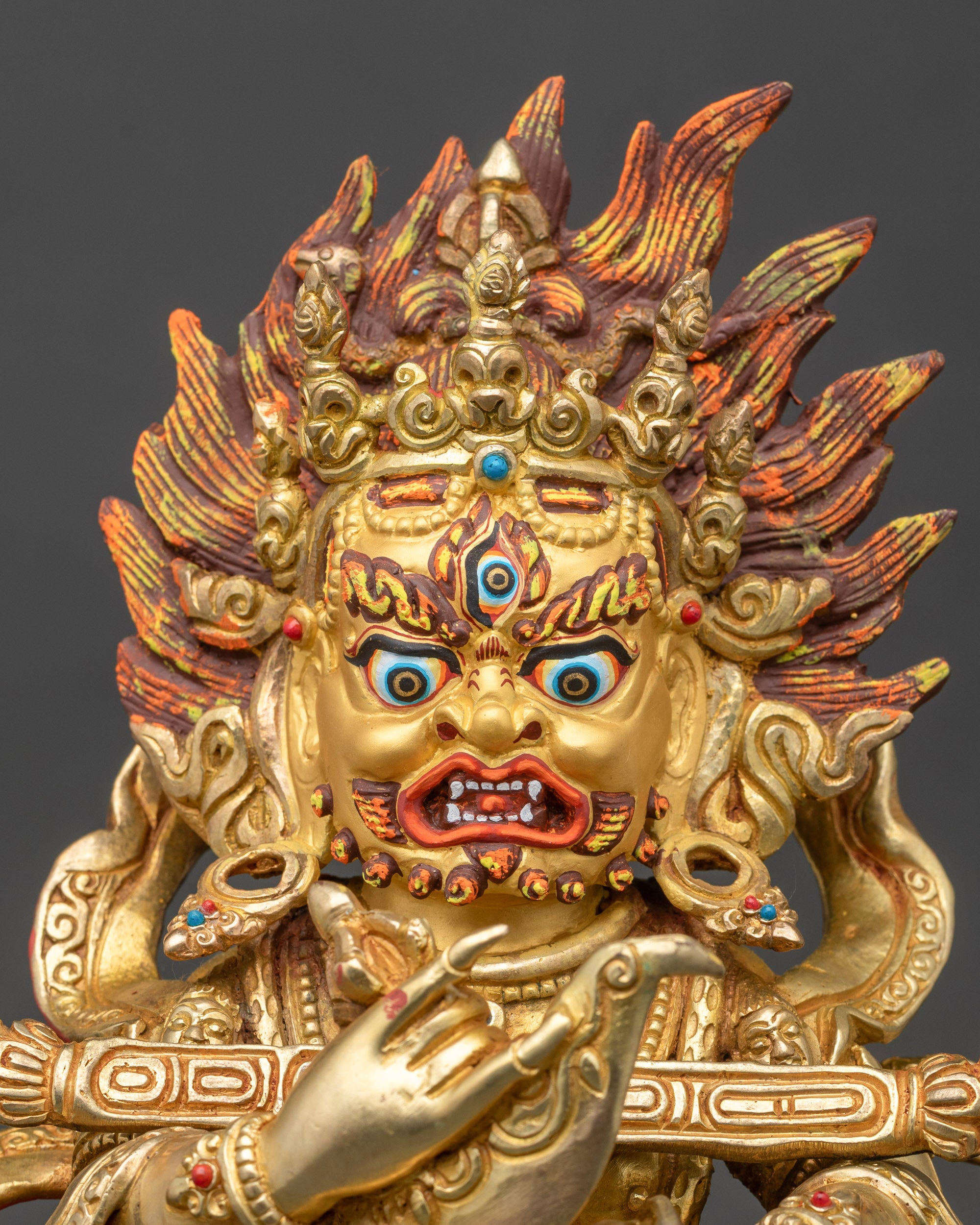 Close view of Sakya Mahakala face with gold gilded finish and fierce expression