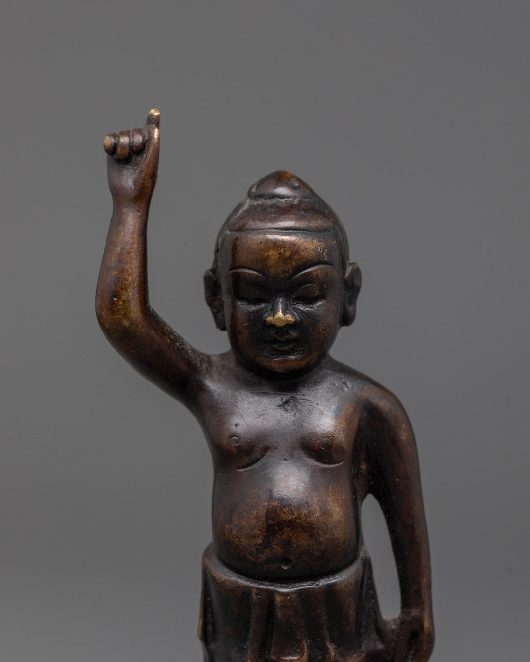Closeup of handcrafted oxidized copper Baby Buddha statue detailing