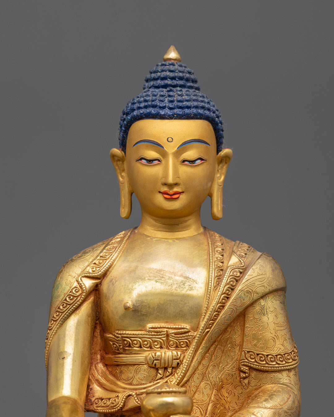 Closeup of intricate carvings and gold fire-gilded body on Shakyamuni Buddha statue