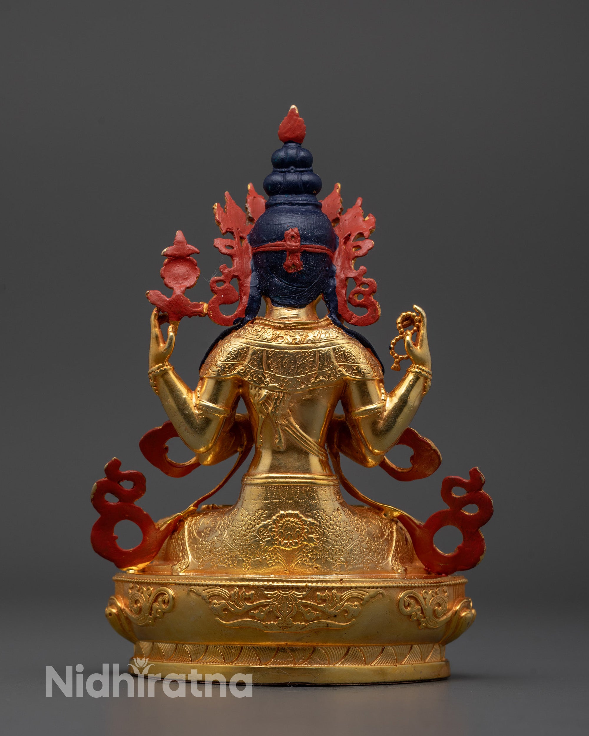 Decorative statue with gold and red elements on a gray background