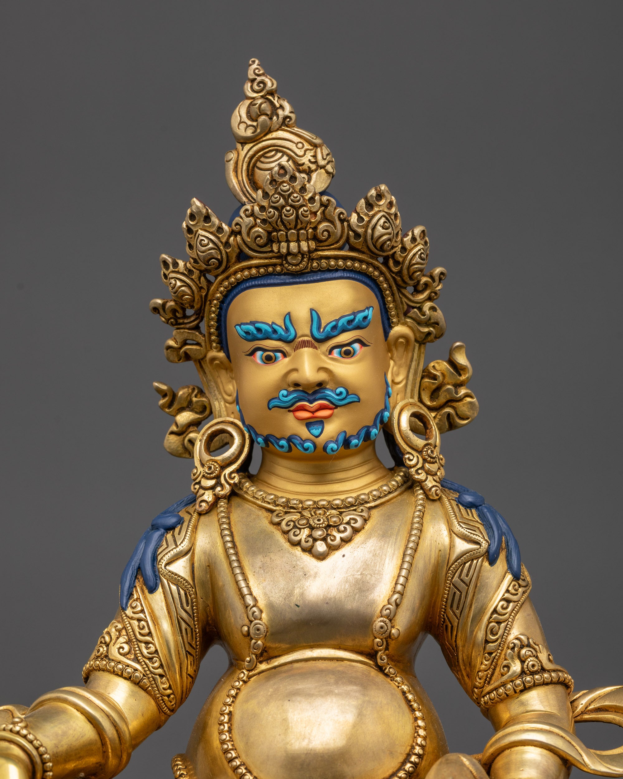 Detailed Close-Up of Dzambhala Statue Showing Jewel Adornments and Robe Patterns