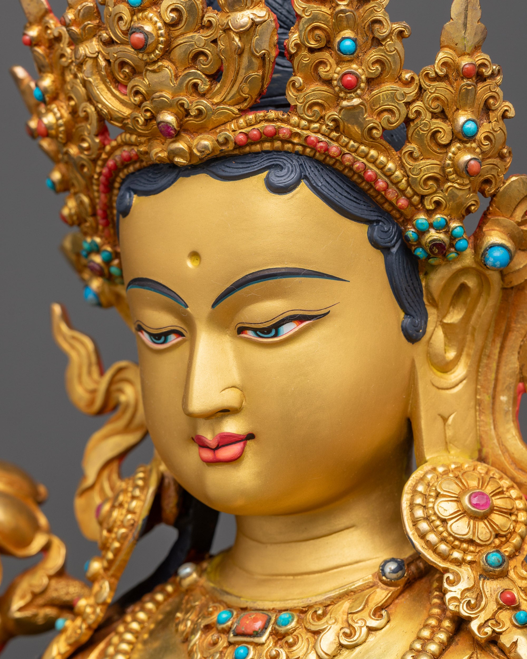 Detailed Side close up of Green Tara face highlighting serene expression and ornate carved jewelry details