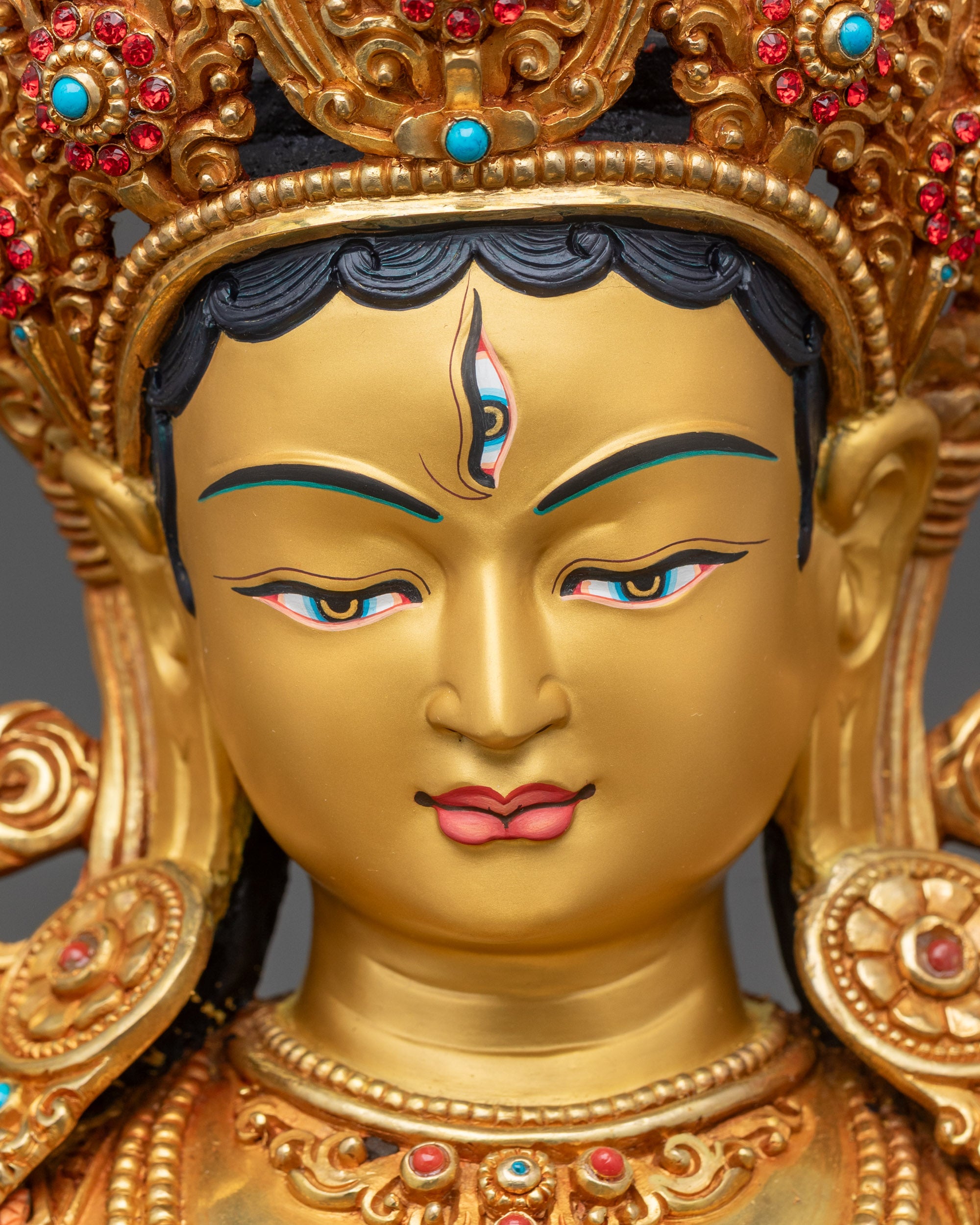 Detailed close-up face of White Tara statue with serene expression and floral halo