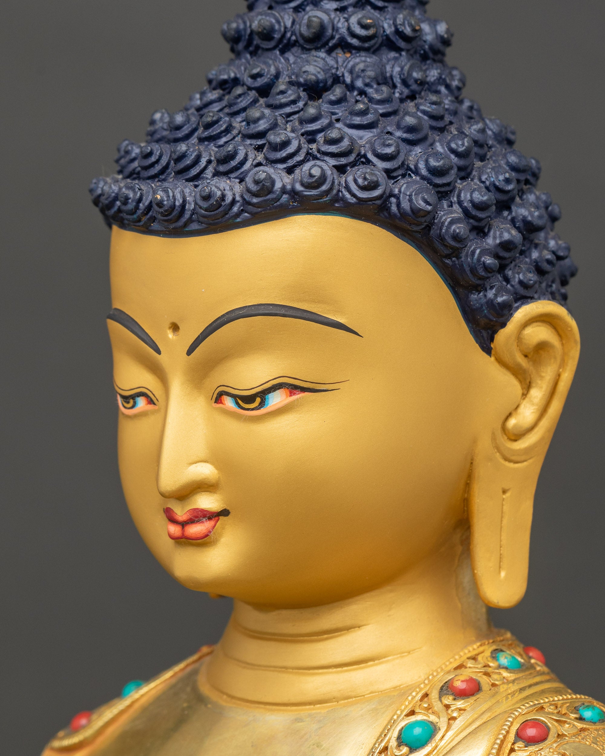 Detailed close-up of Buddha face, serene expression with semi-precious stone accents