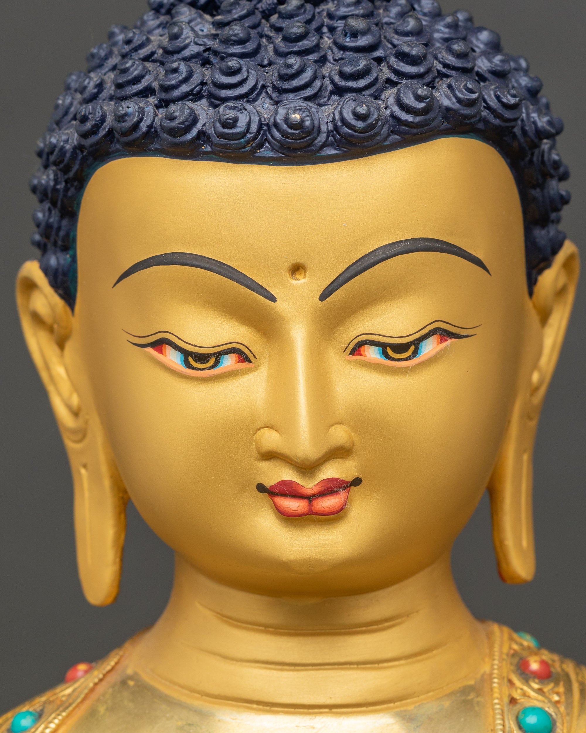 Detailed closea-up of Buddha face, serene expression with semi-precious stone accents