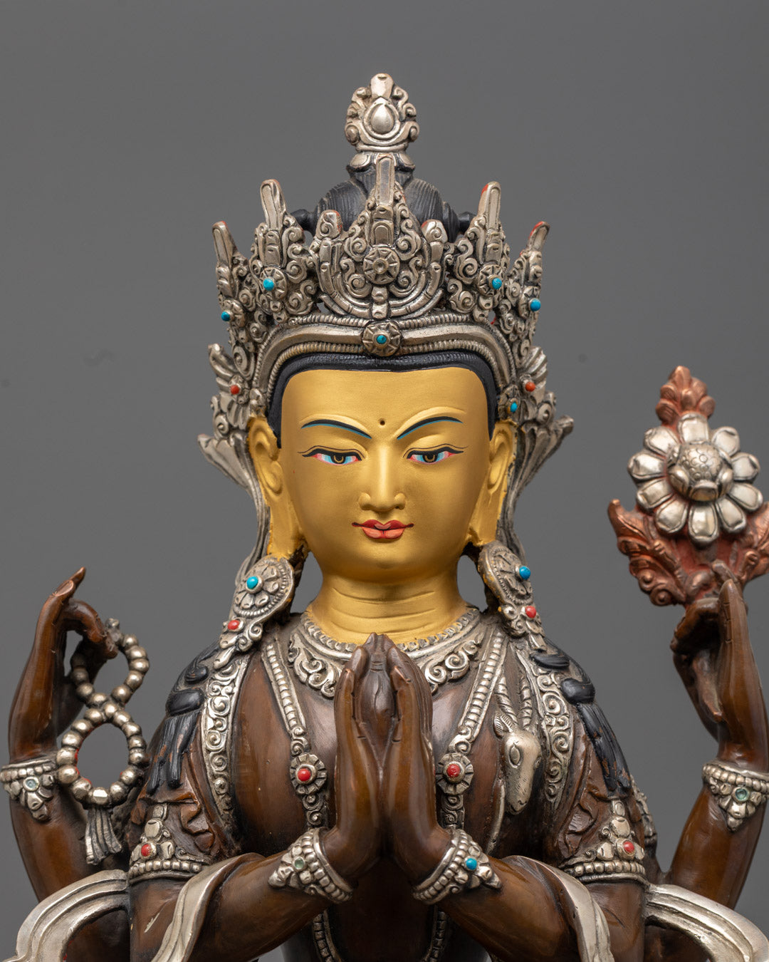 Detailed close-up of Chenrezig statue's serene 24K gold face with silver finishing, showcasing masterful Nepalese metal craftsmanship and spiritual expression