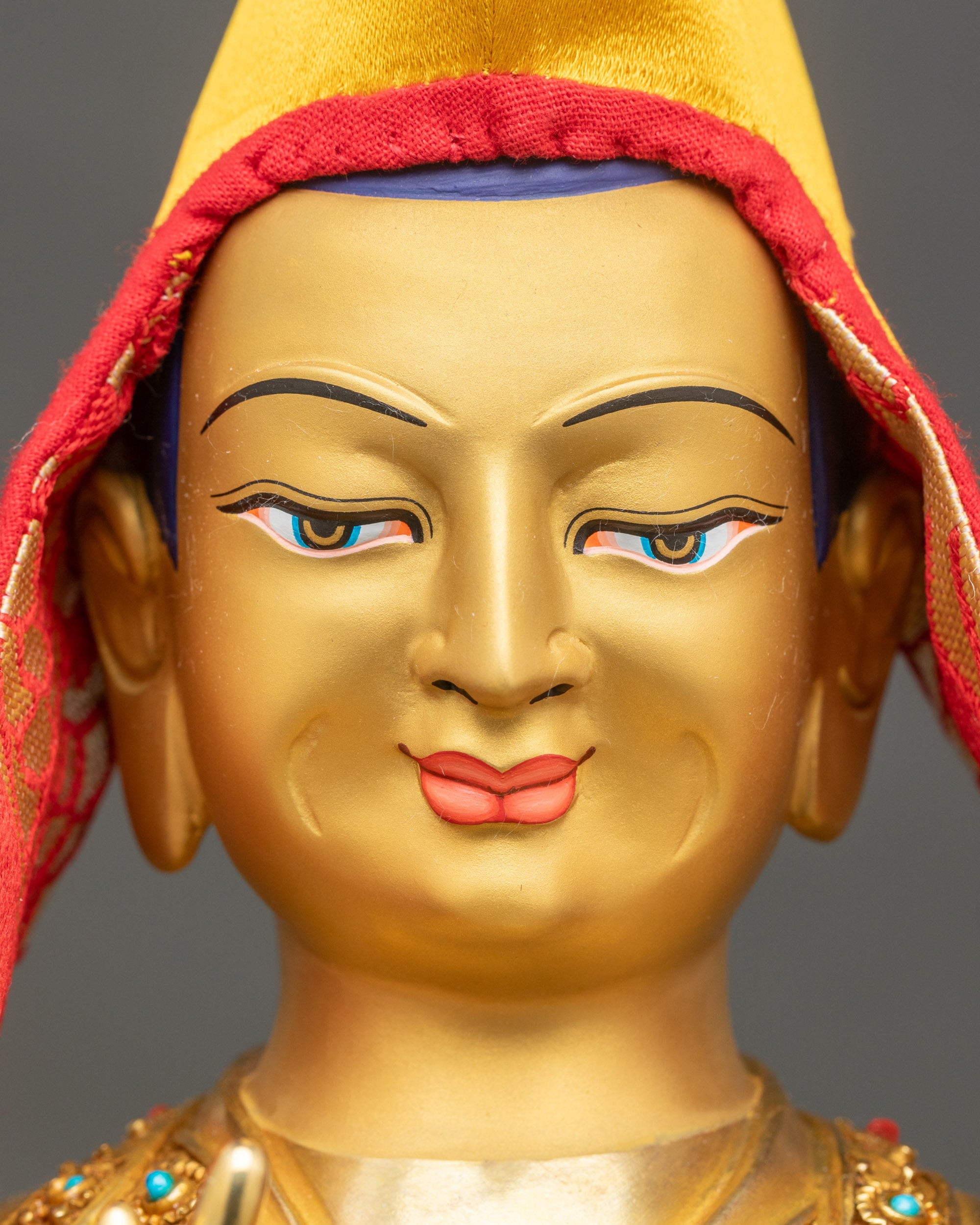 Detailed close-up of Je Tsongkhapa statue face, hand-painted eyes and gentle compassionate expression