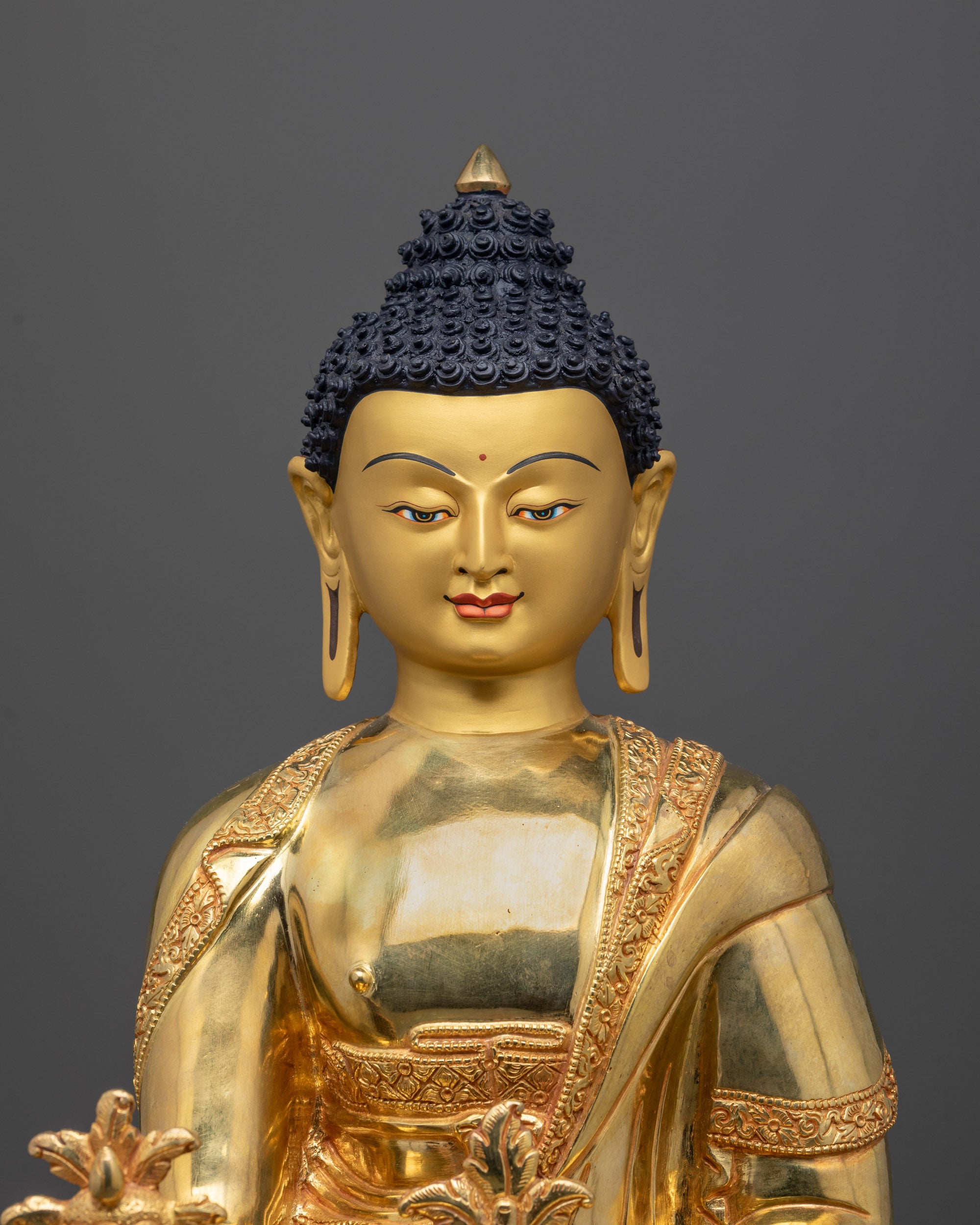Detailed close-up of Medicine Buddha’s serene face with radiant golden finish