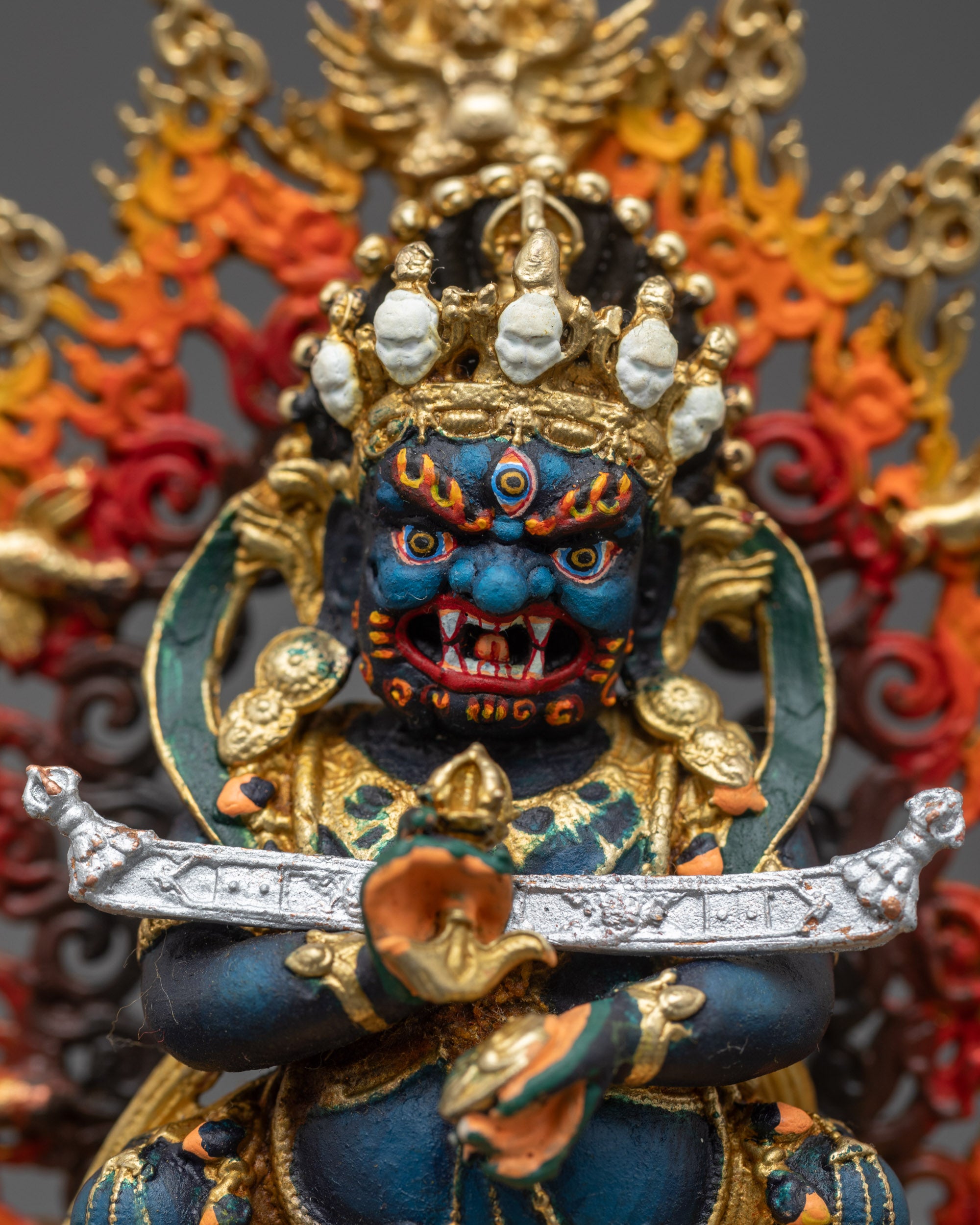 Detailed close-up of Sakya Mahakala face showing wrathful expression and gold plating