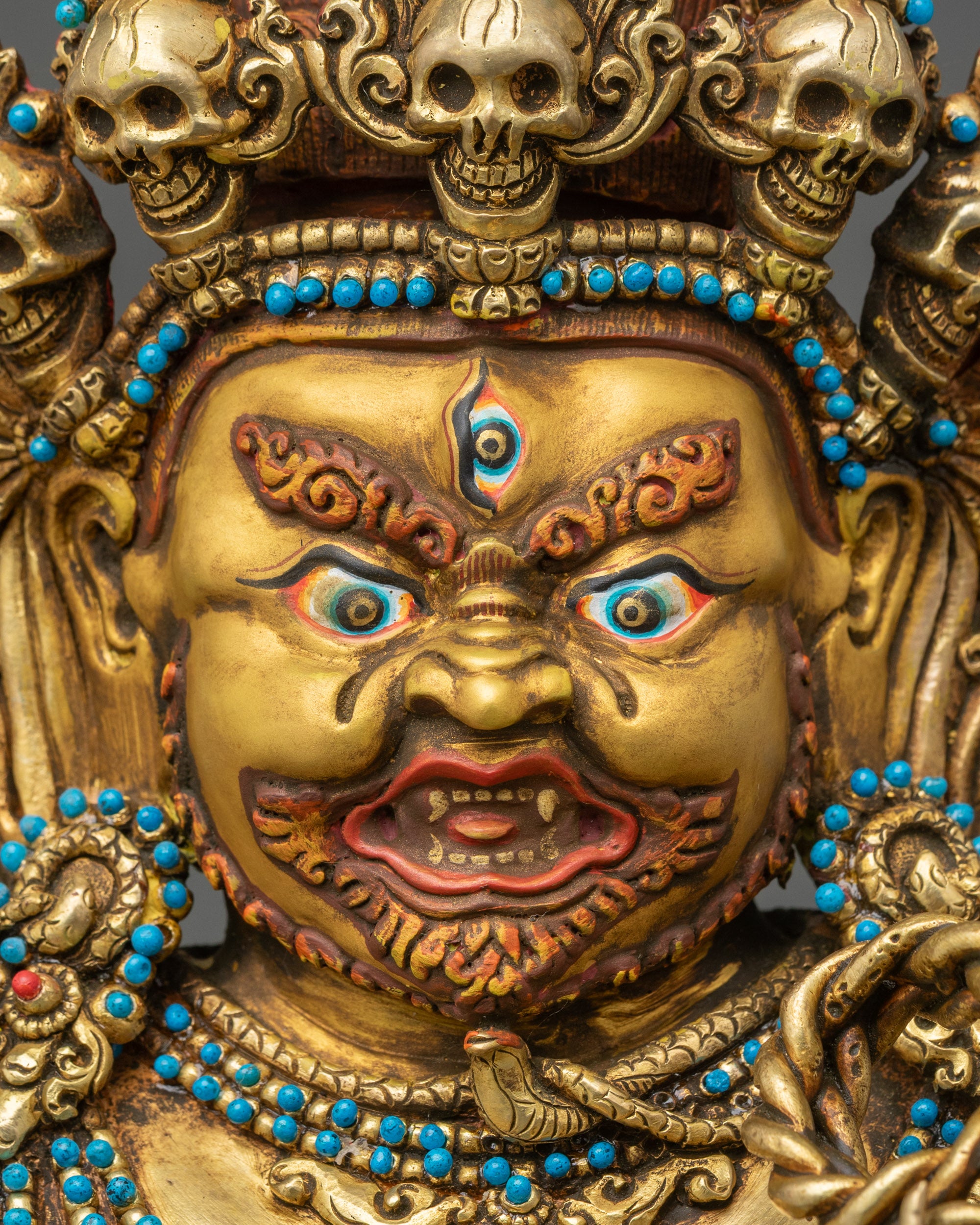 Detailed close-up of Vajrapani face, expressive features with gold-gilded finish