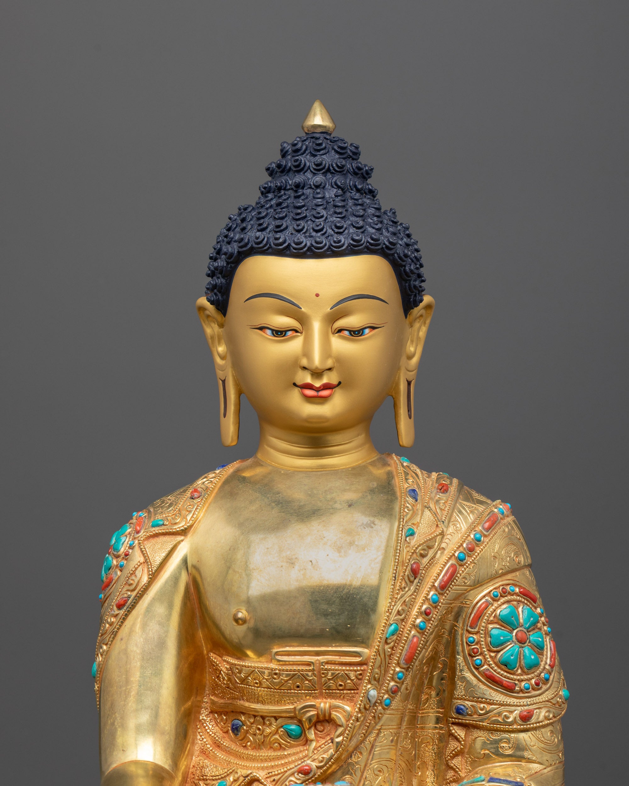 Detailed close-up of a golden Shakyamuni Buddha statue with halo