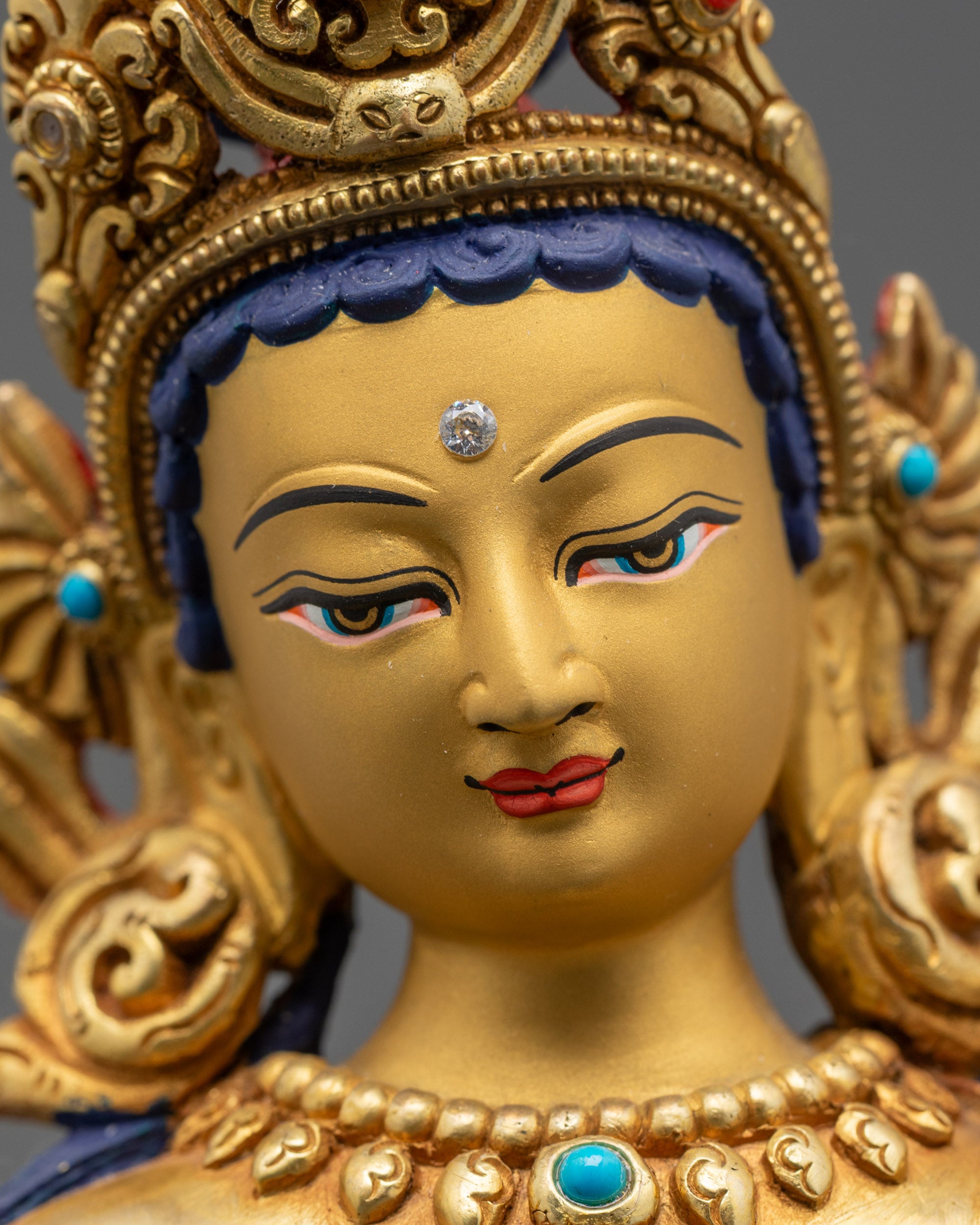 Detailed close up face Padmapani statue with five-jeweled crown and serene expression