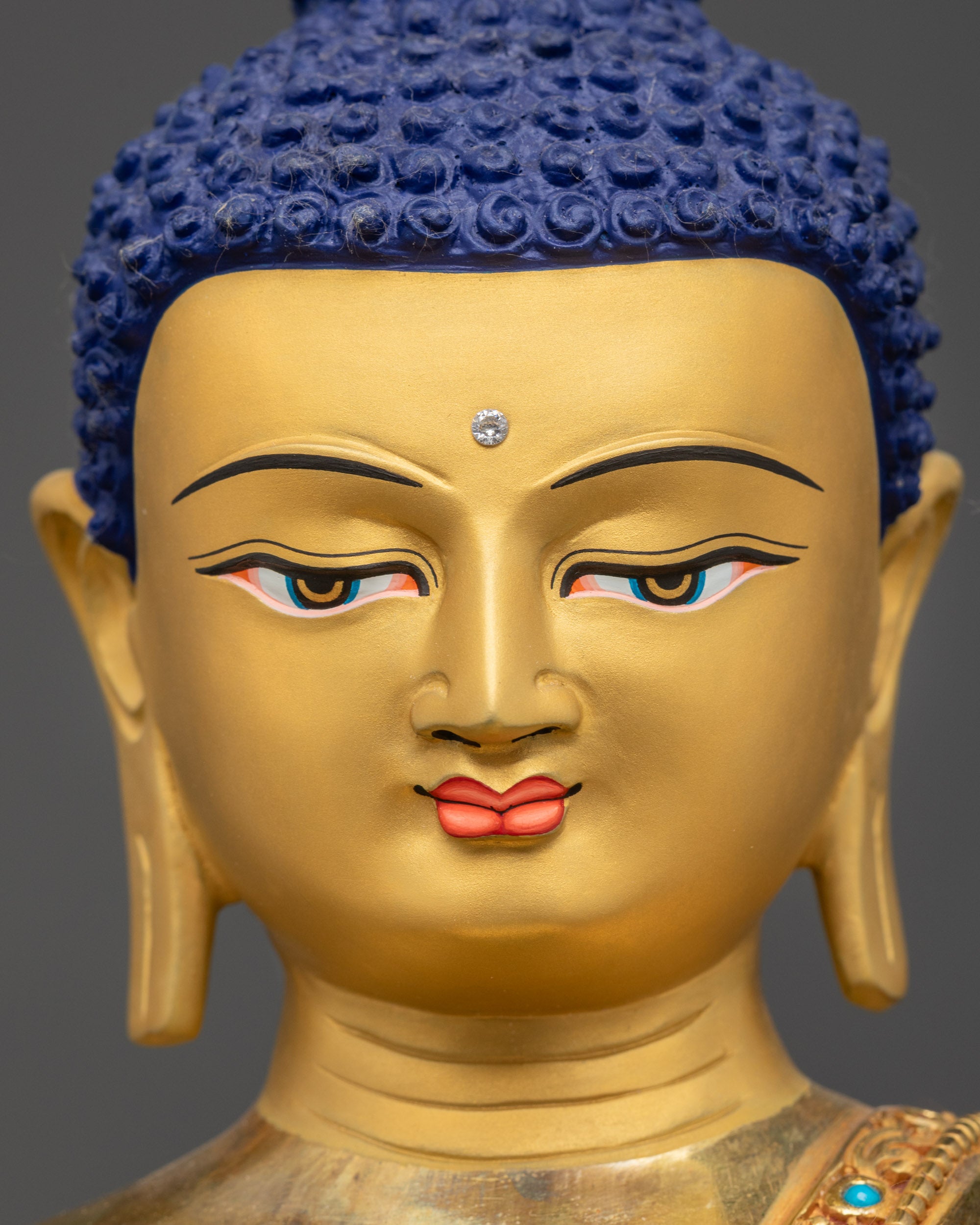 Detailed close up face of Amitabha Buddha with serene expression and semi-precious stones
