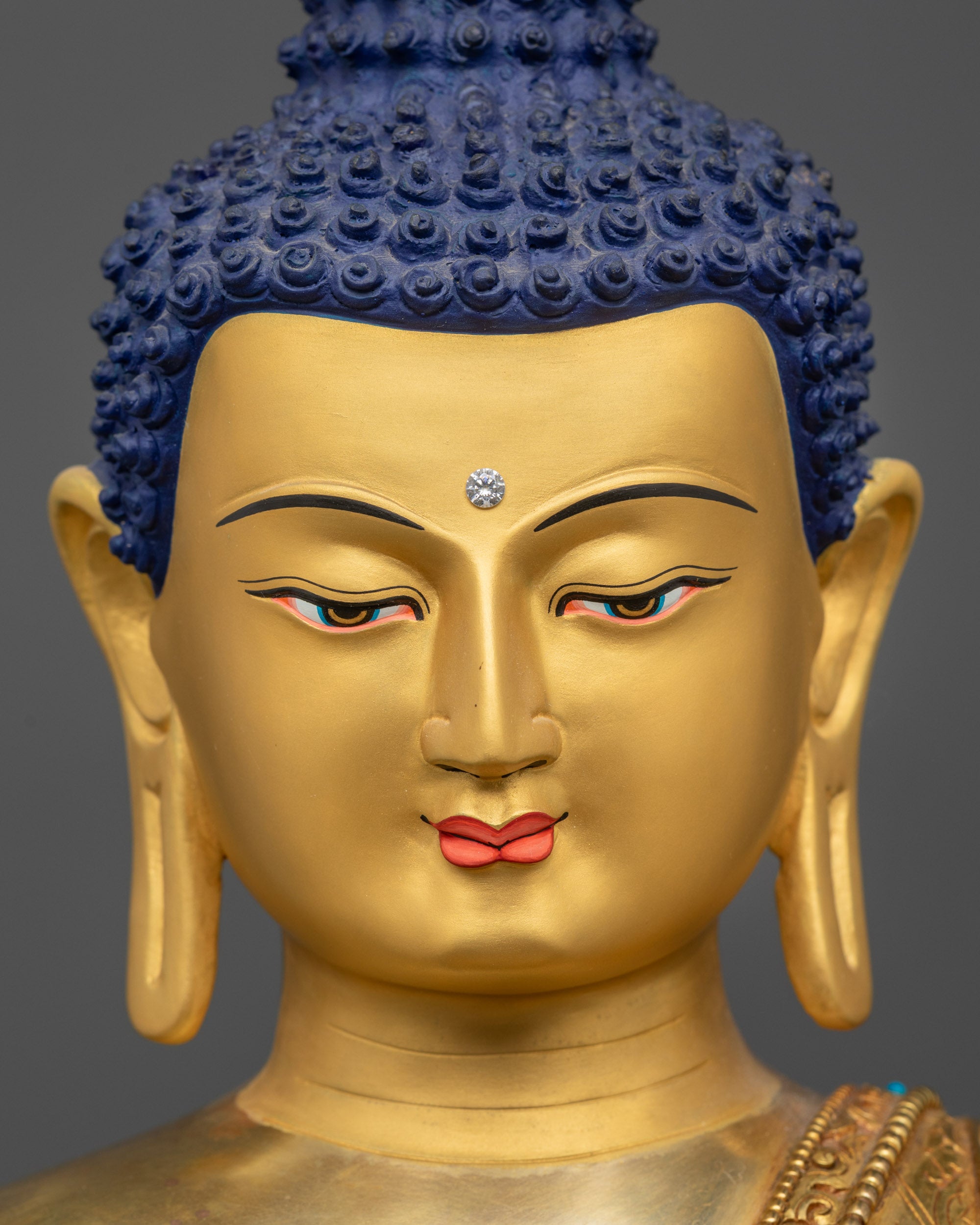 Detailed close up face of Shakyamuni Buddha with 24K gold-gilded features and calm gaze