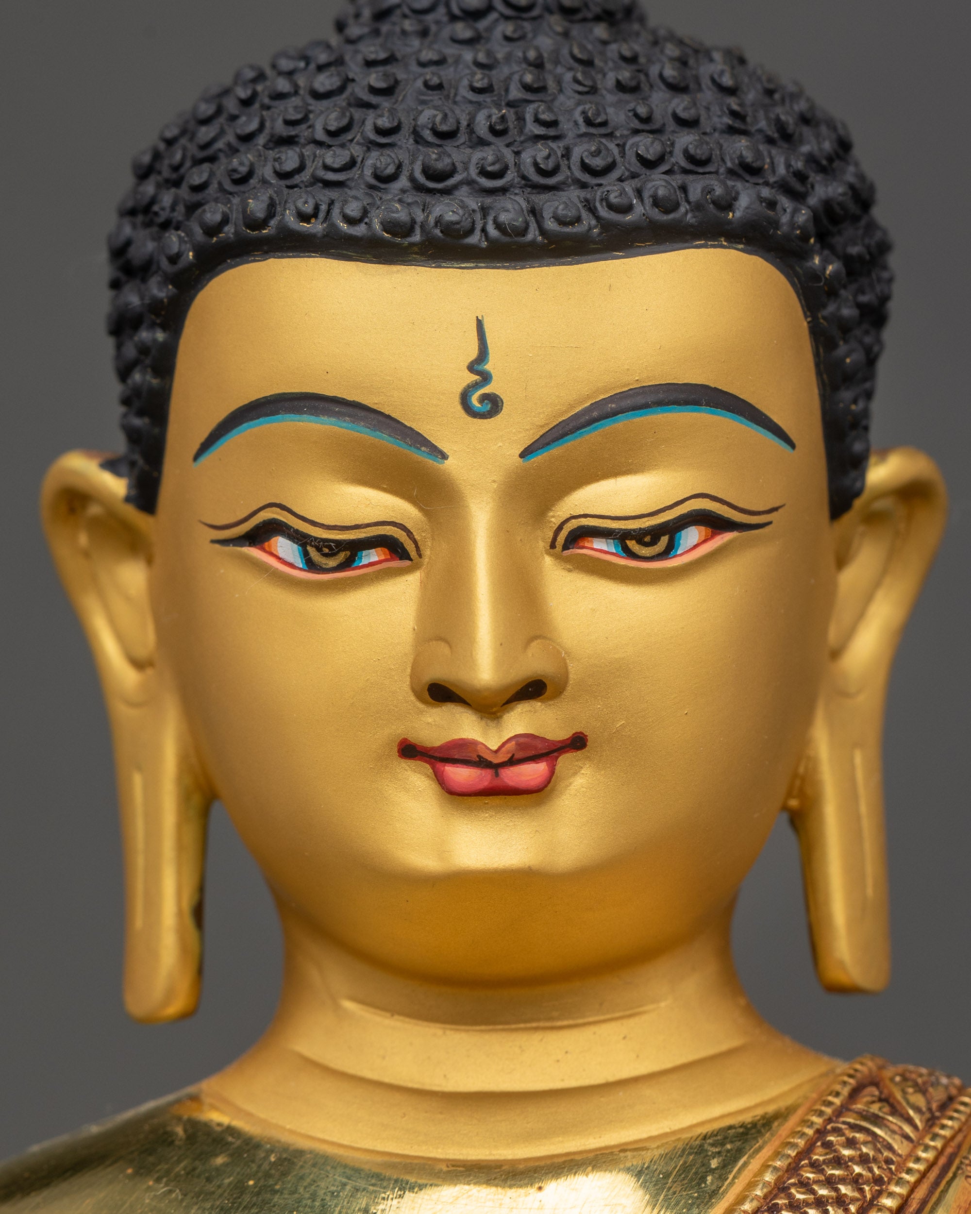 Detailed close up face of Shakyamuni Buddha with tranquil expression and gold gilding