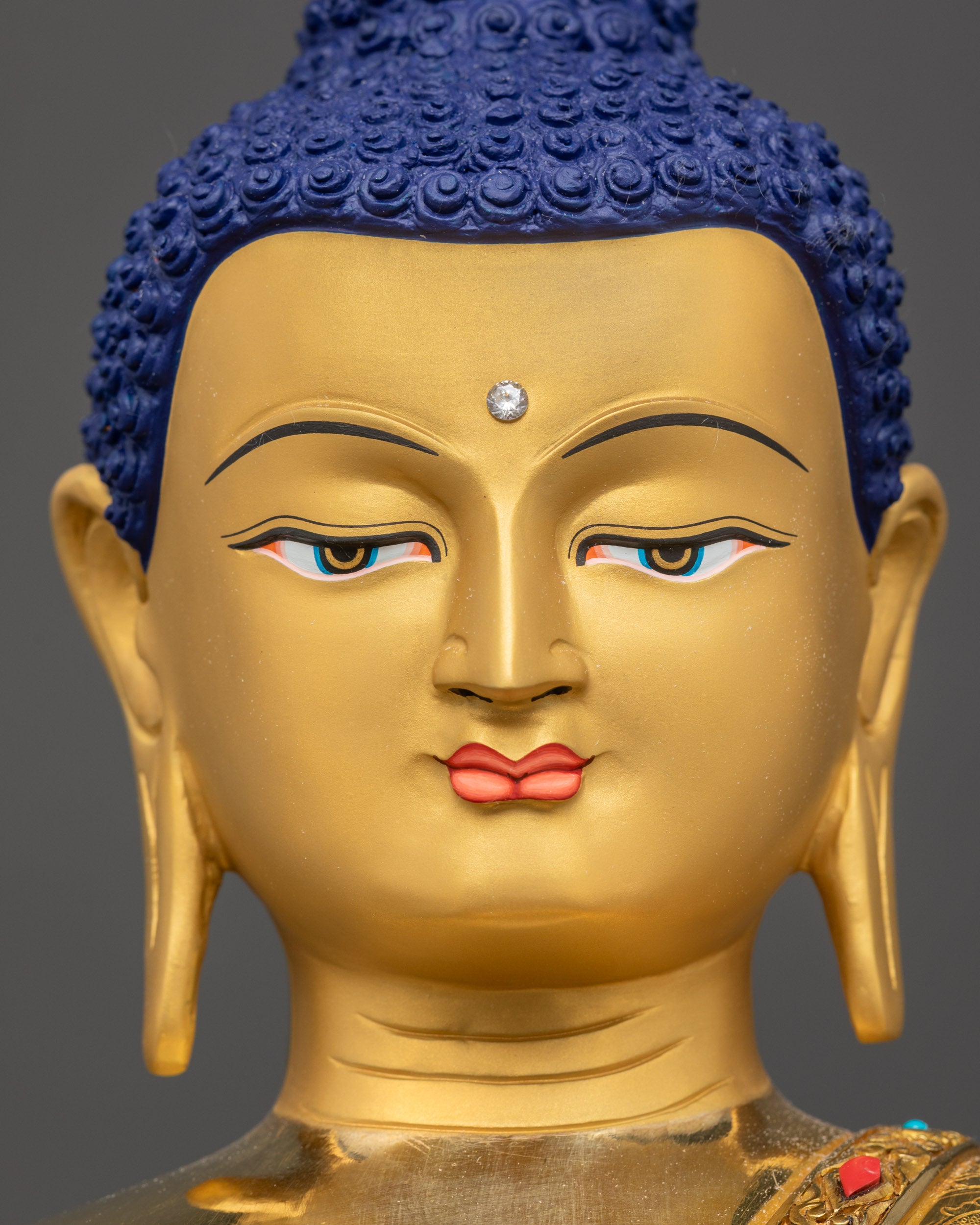Detailed close up face of Shakyamuni Buddha with turquoise and coral inlay