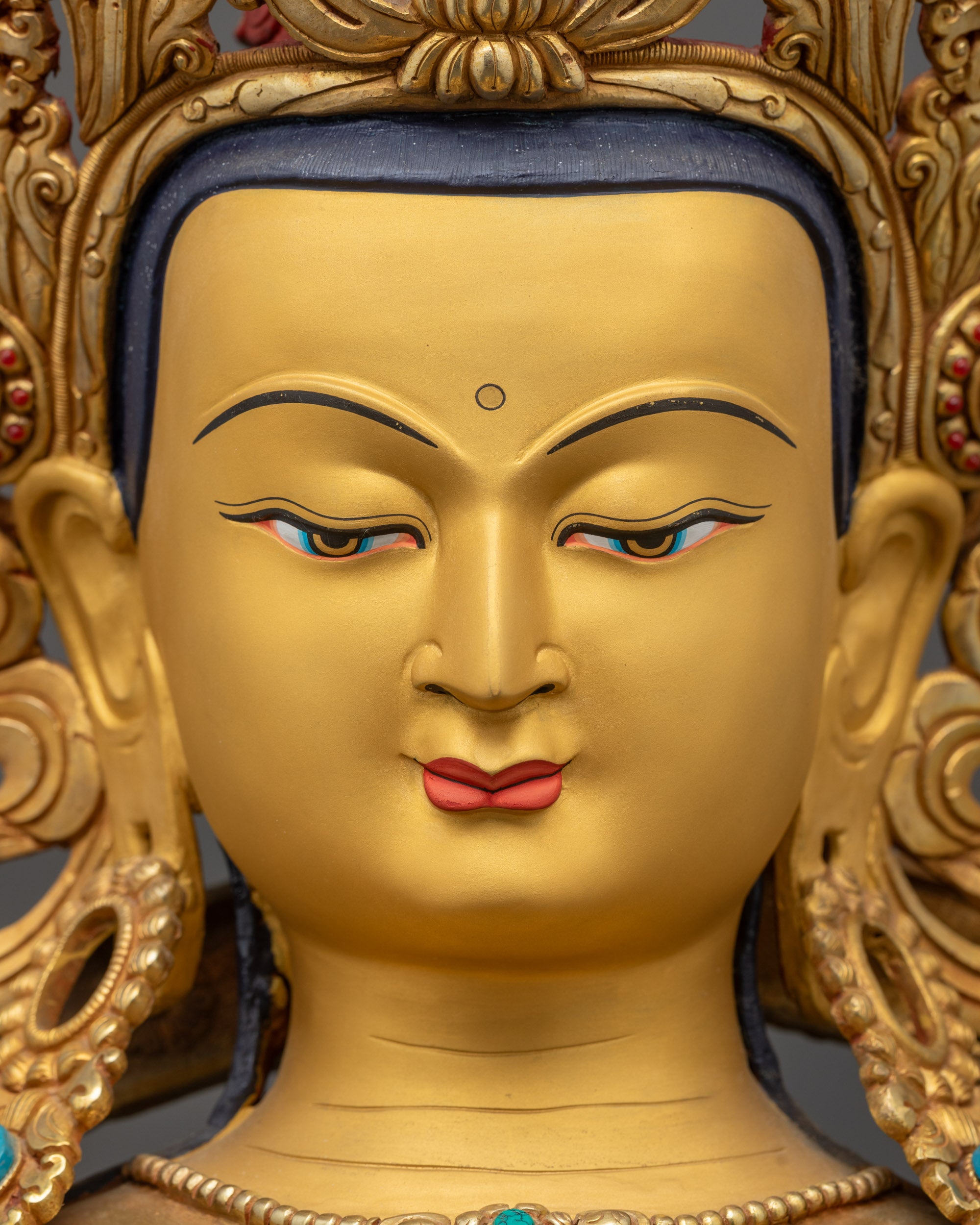 Detailed close up face of Vajradhara statue showing tranquil gold-gilded features