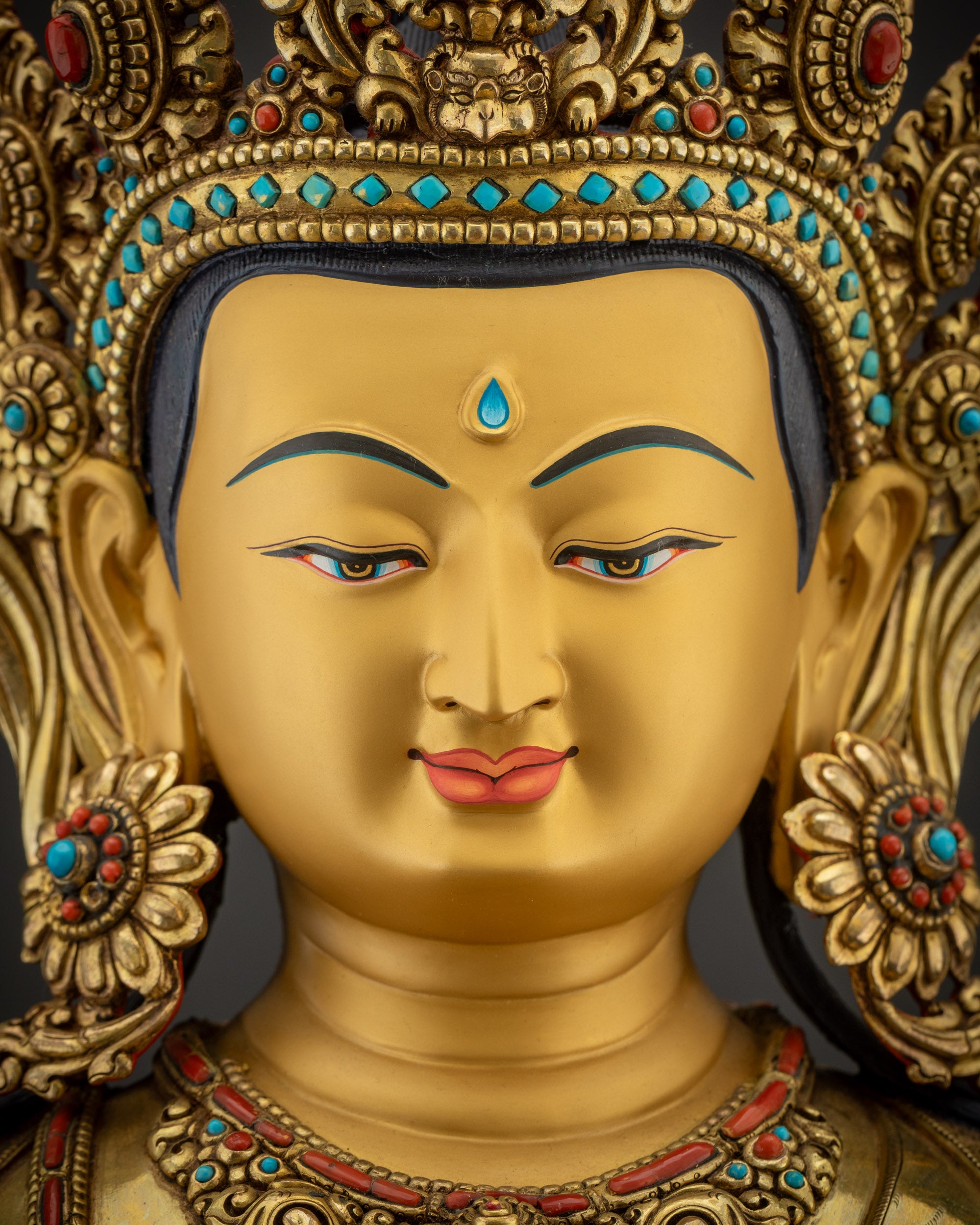 Detailed close up of Avalokiteshvara gold-gilded face Bodhisattva sculpture