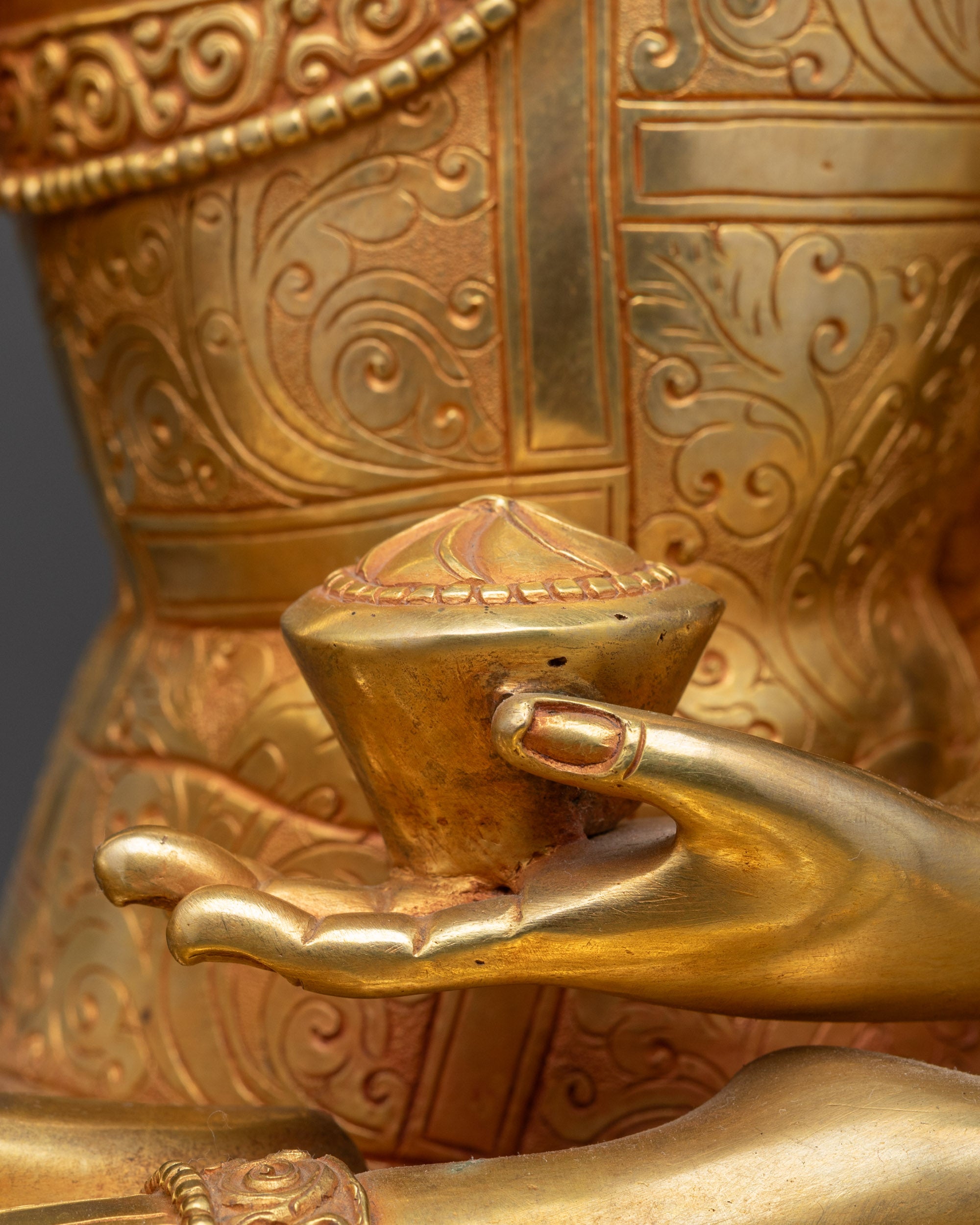 Detailed close up of Buddha begging bowl held in left hand, symbolizing compassion