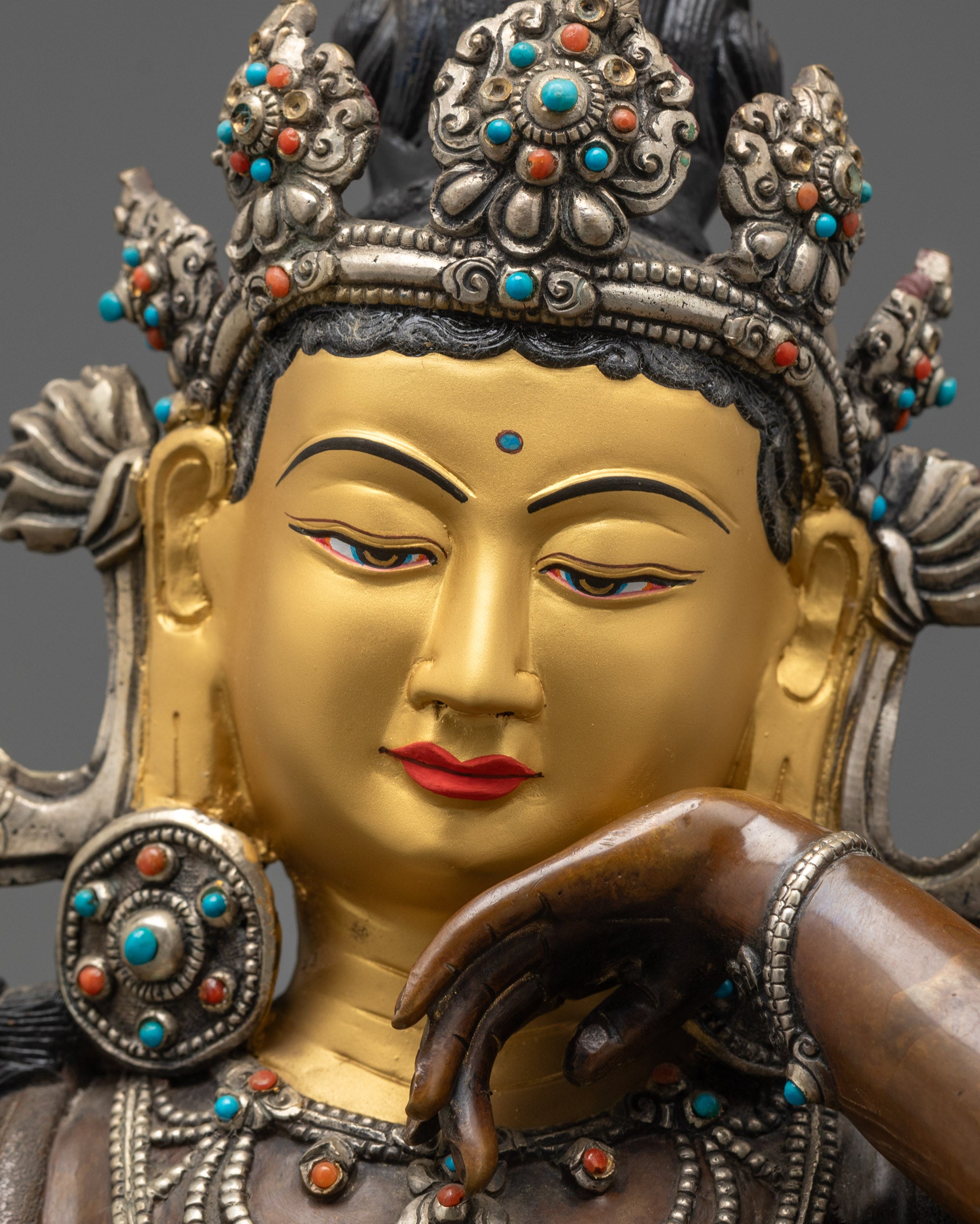Detailed close up of Chenrezig face with gold-gilded expression and serene features