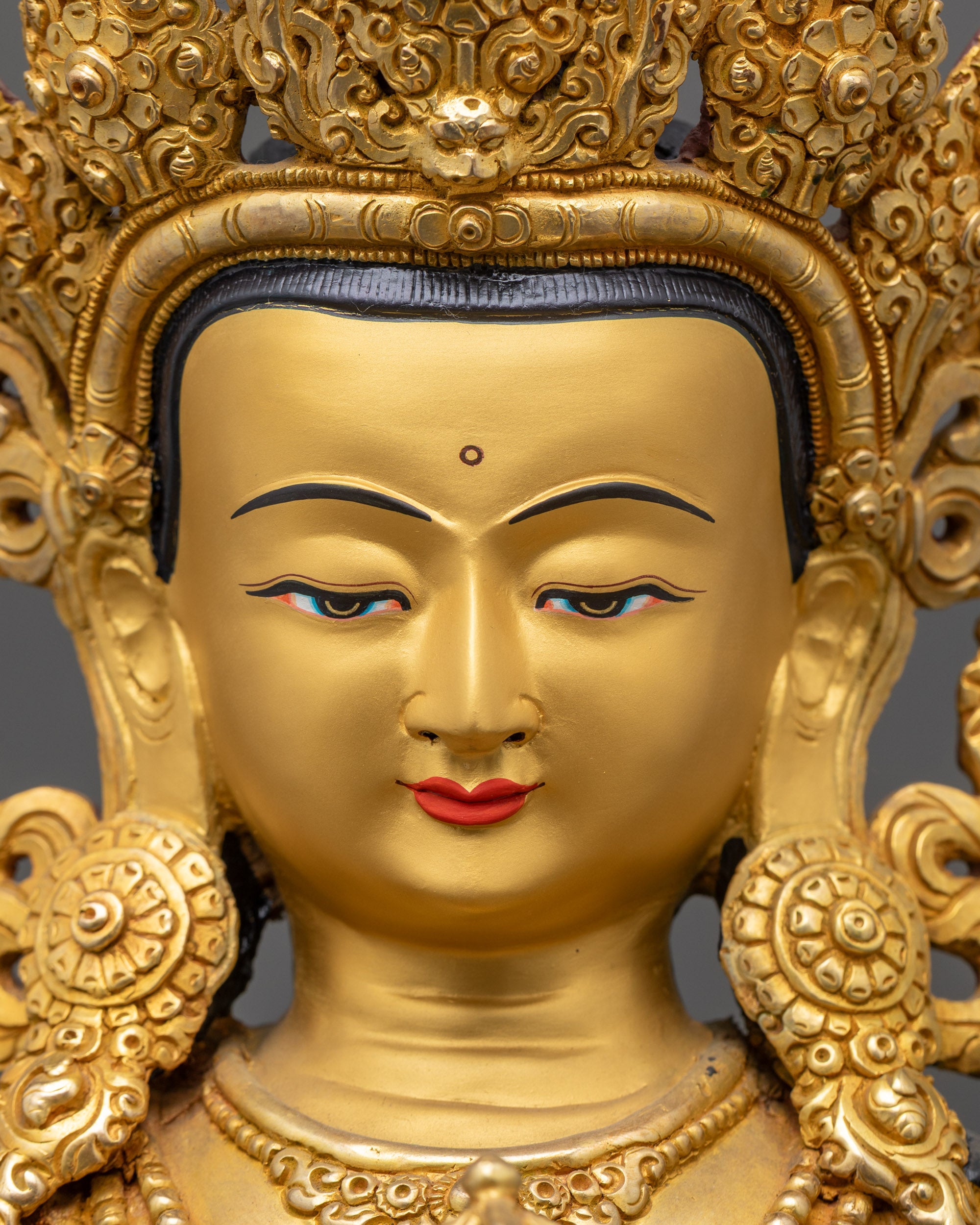 Detailed close up of Dorje Sempa statue showing serene gold-gilded face